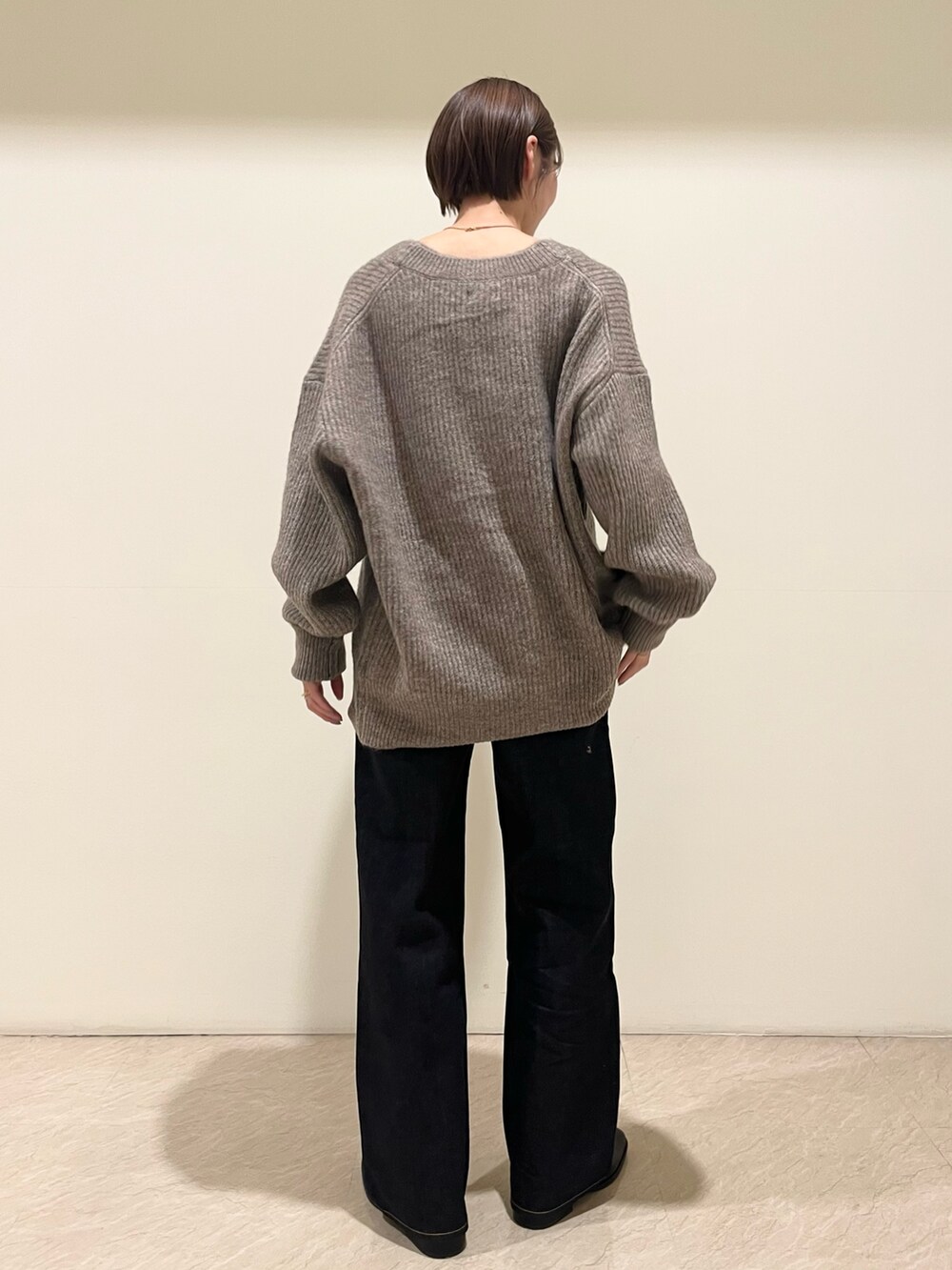 グレー系のカーディガン/ボレロ、ブルー系のデニムパンツを着用したレディースの秋コーディネートの3枚目の写真