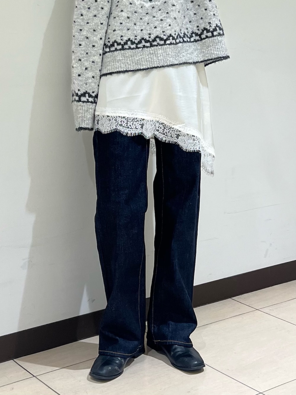 グレー系のニット/セーター、ホワイト系のキャミソール、ブルー系のデニムパンツを着用したレディースの冬コーディネートの5枚目の写真