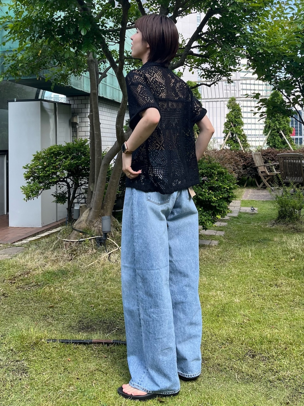 ブラック系のシャツ/ブラウス、ブルー系のデニムパンツを着用したレディースの夏コーディネートの4枚目の写真