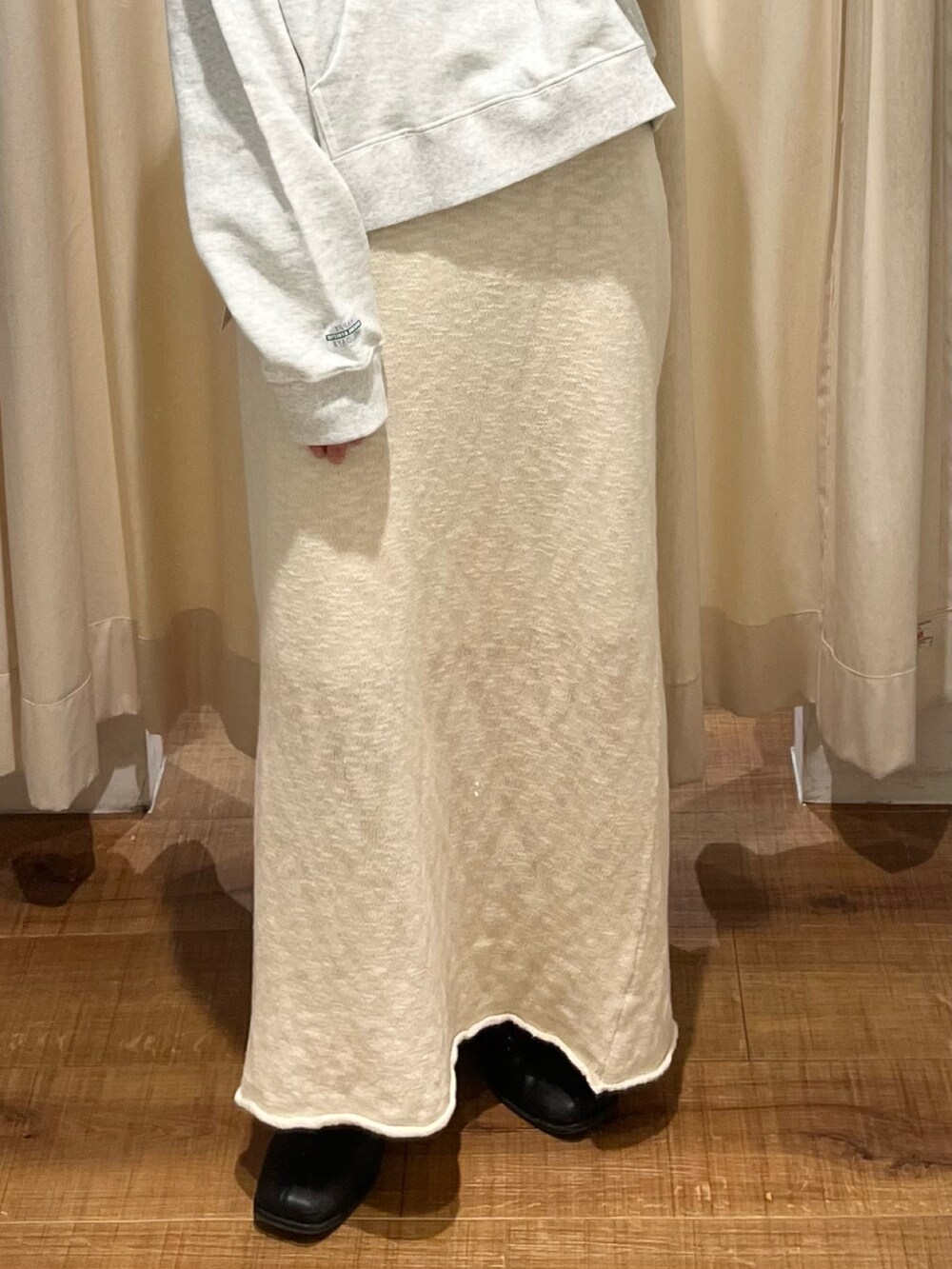 グレー系のパーカー、ホワイト系のスカートを着用したレディースの冬コーディネートの5枚目の写真