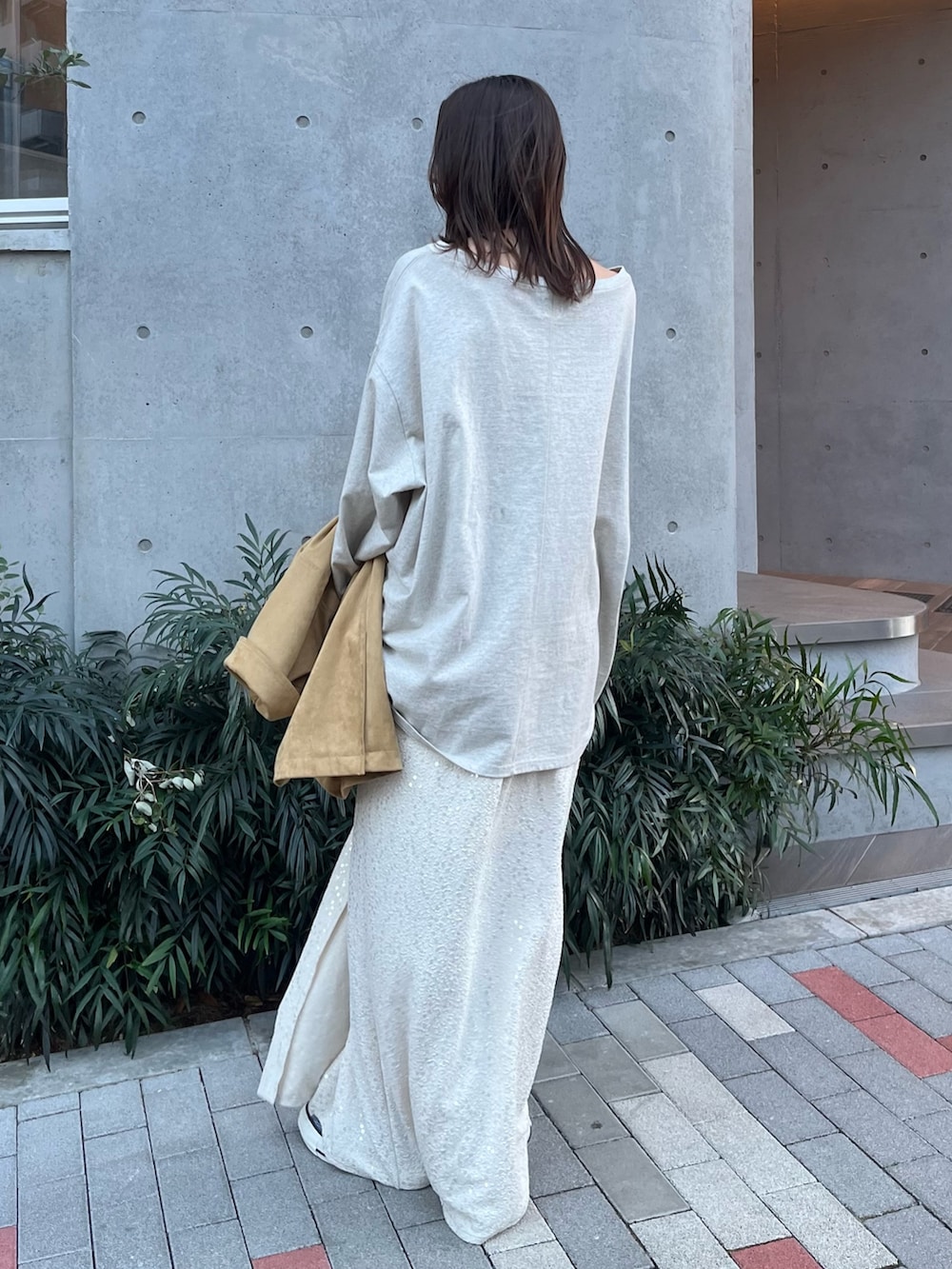 イエロー系のテーラードジャケット、グレー系のTシャツ/カットソー、ホワイト系のスカートを着用したレディースの冬コーディネートの7枚目の写真