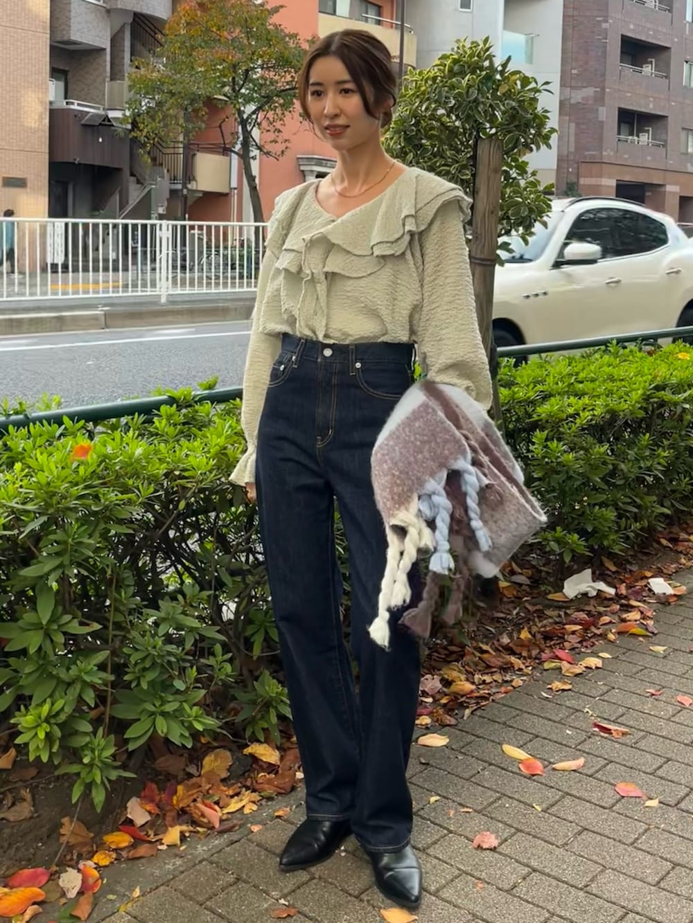 ブルー系のシャツ/ブラウス、グレー系のチェスターコート、ブルー系のデニムパンツを着用したレディースの秋コーディネートの4枚目の写真