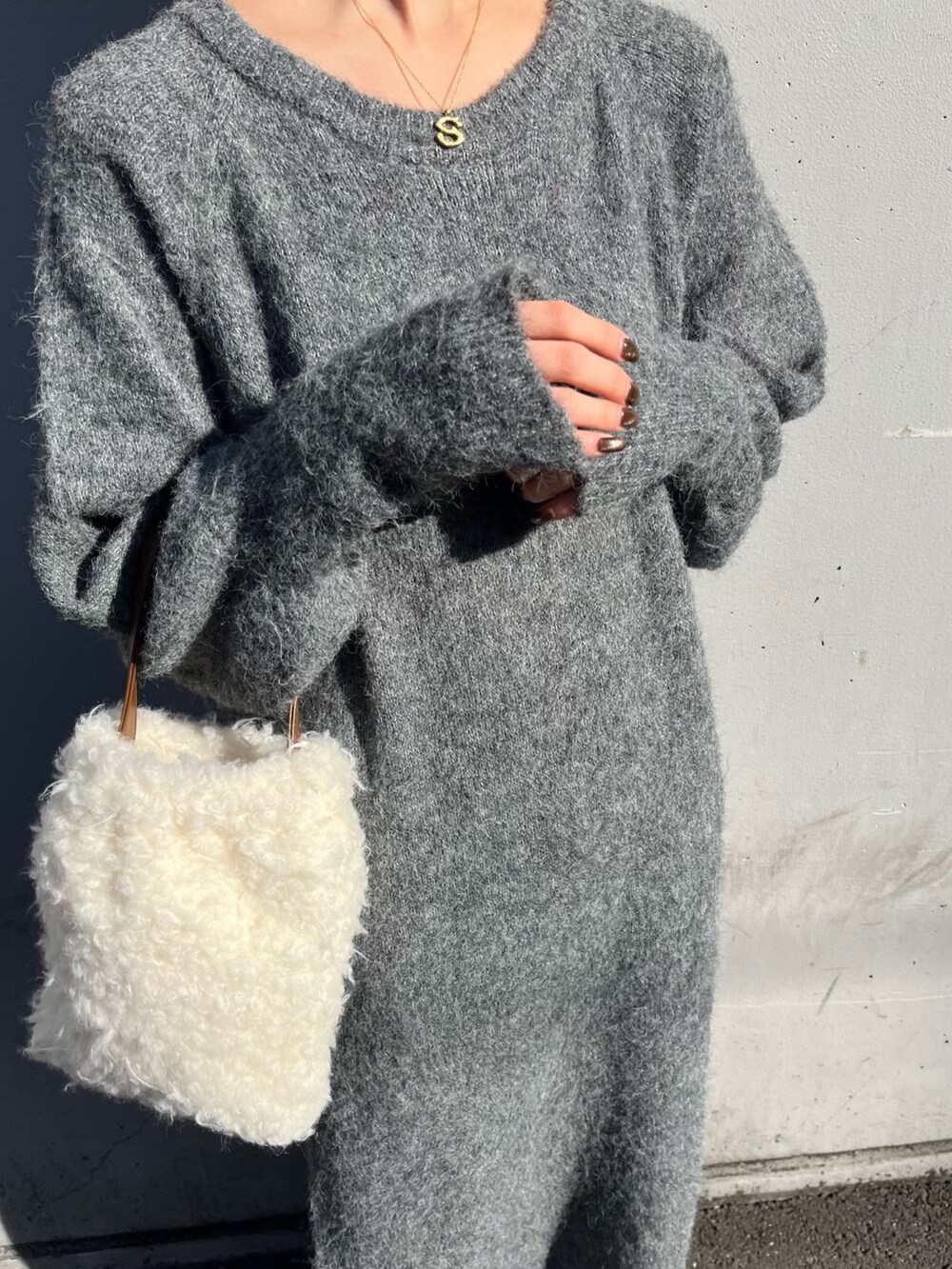 ホワイト系のハンドバッグ、グレー系のワンピースを着用したレディースの秋コーディネートの5枚目の写真