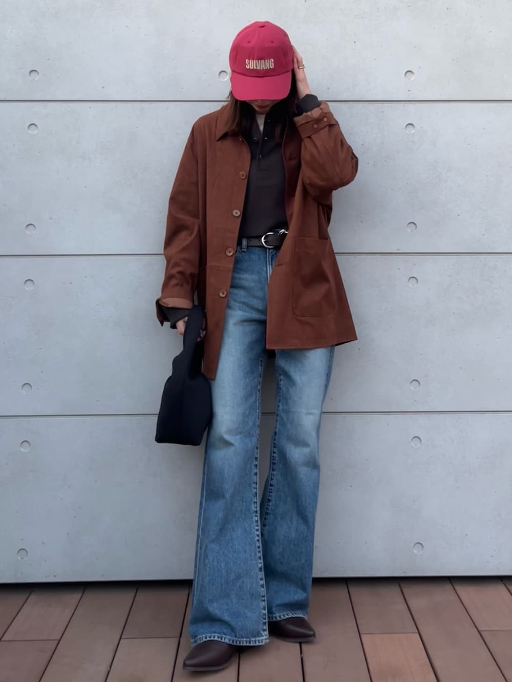 グレー系のTシャツ/カットソー、ブルー系のデニムパンツ、ブラック系のハンドバッグを着用したレディースの冬コーディネートの2枚目の写真