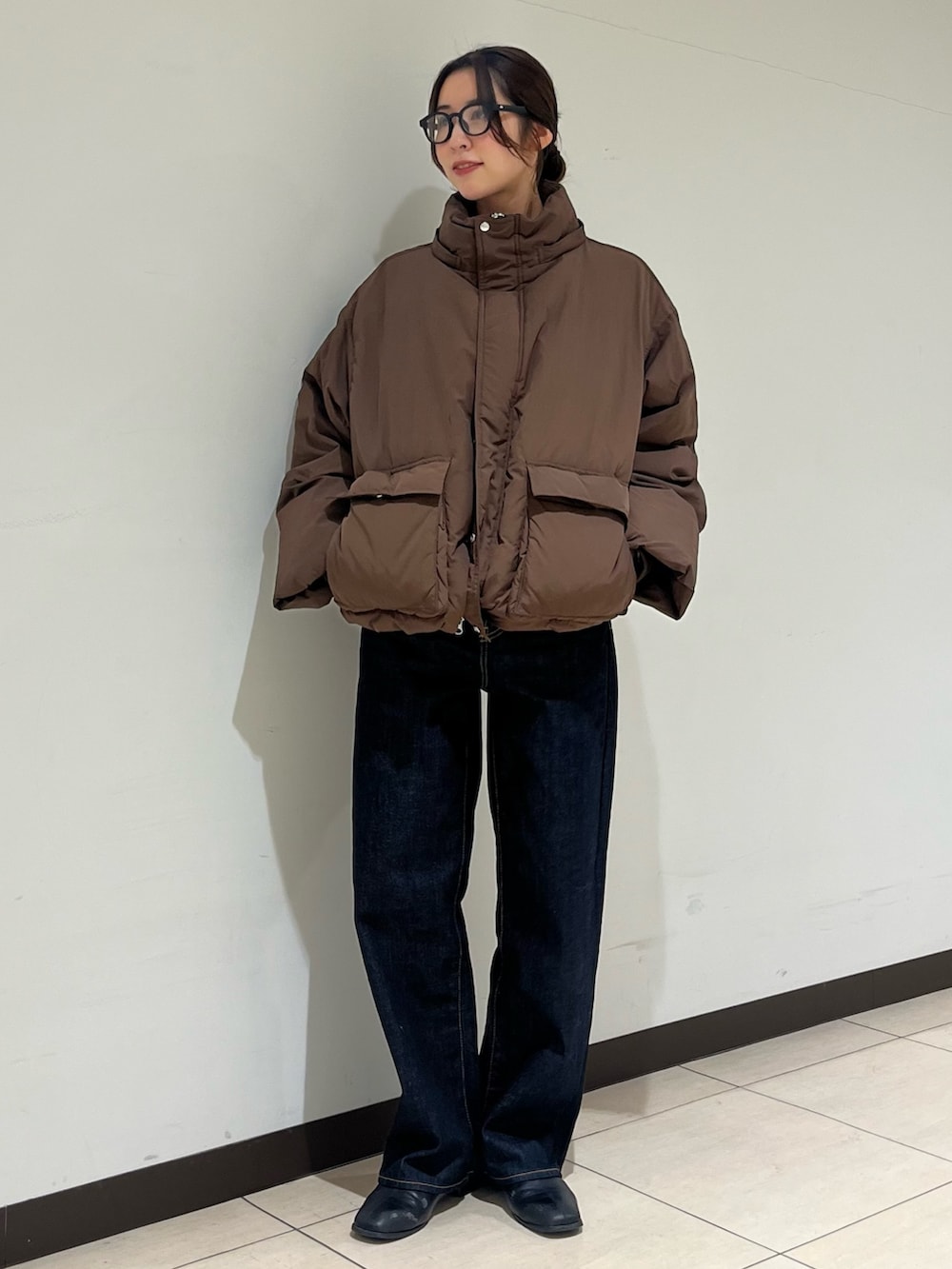 ブラウン系のダウンジャケット/コート、ブルー系のデニムパンツ、ブラック系のサングラスを着用したレディースの冬コーディネートの4枚目の写真
