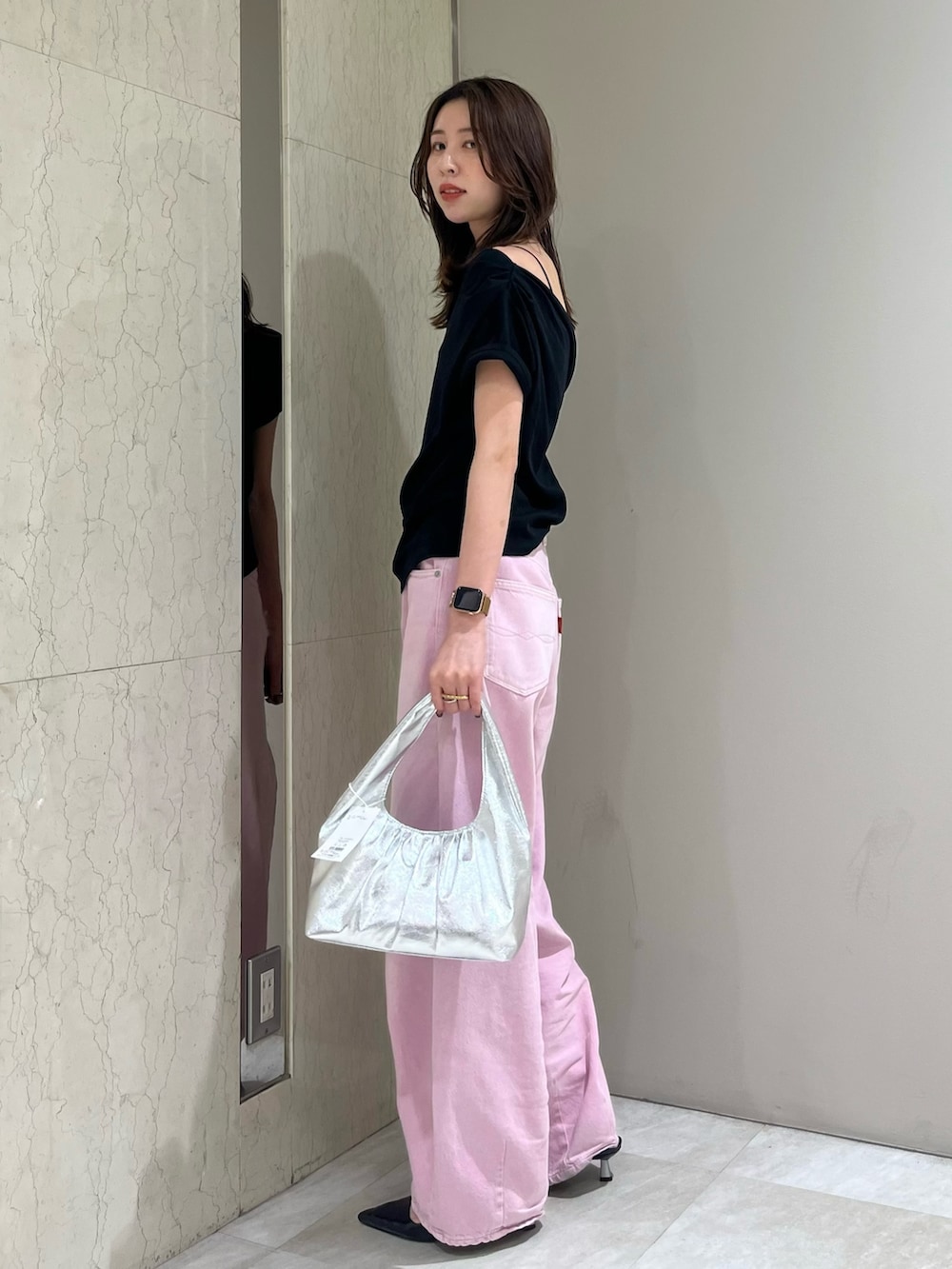 ブラック系のTシャツ/カットソー、ピンク系のデニムパンツ、シルバー系のハンドバッグを着用したレディースの春コーディネートの2枚目の写真