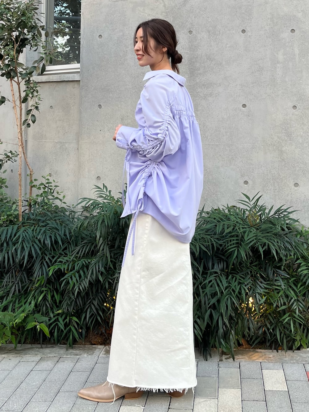 パープル系のシャツ/ブラウス、ホワイト系のスカート、ベージュ系のブーツを着用したレディースの冬コーディネートの2枚目の写真