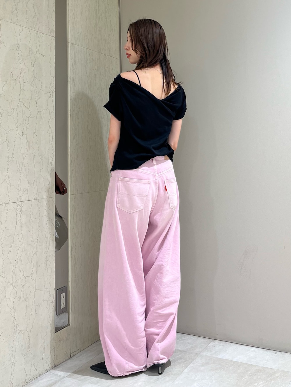 ブラック系のTシャツ/カットソー、ピンク系のデニムパンツ、シルバー系のハンドバッグを着用したレディースの春コーディネートの3枚目の写真