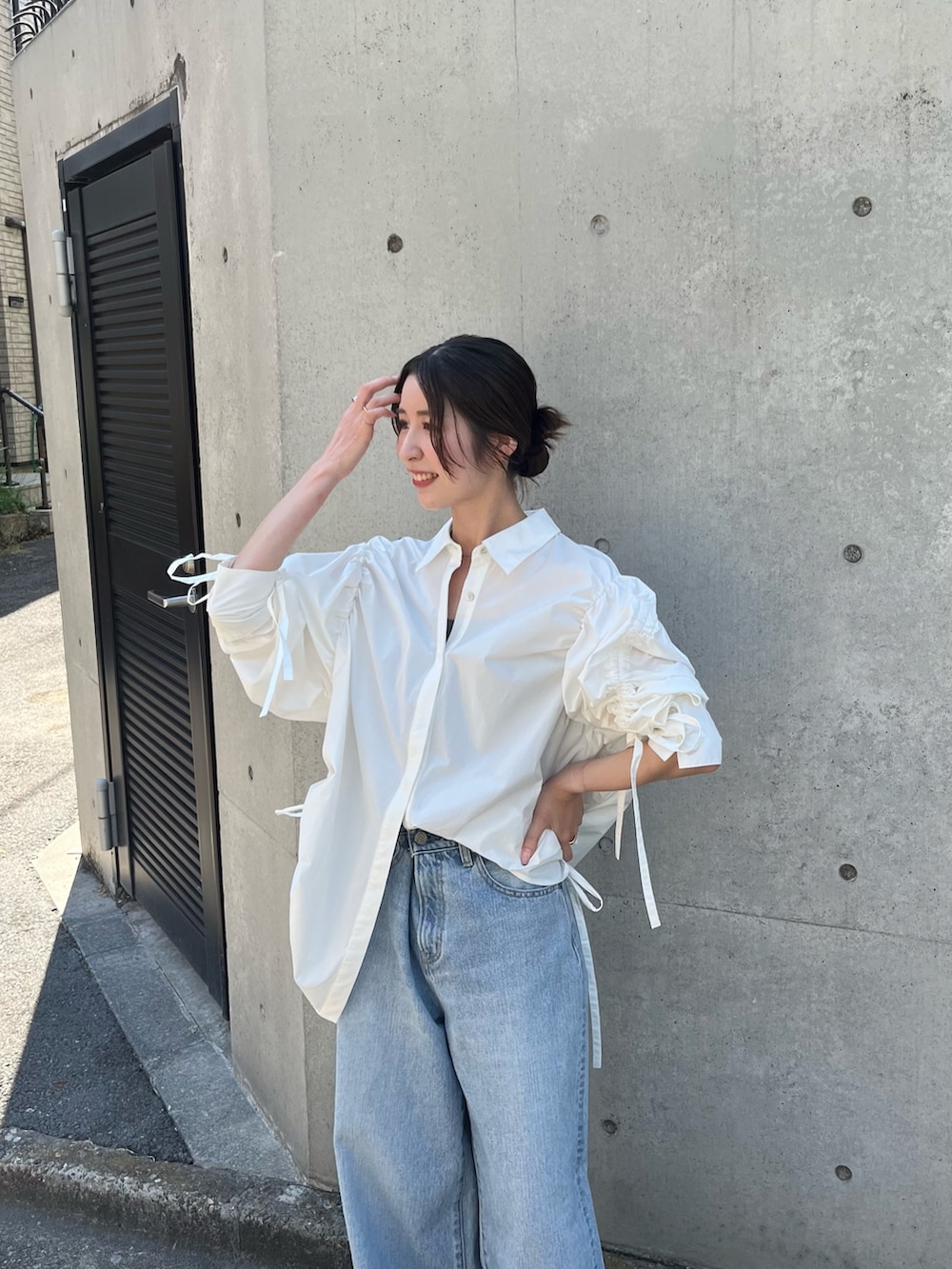 ホワイト系のシャツ/ブラウス、ブルー系のデニムパンツ、ベージュ系のローファーを着用したレディースの秋コーディネートの4枚目の写真