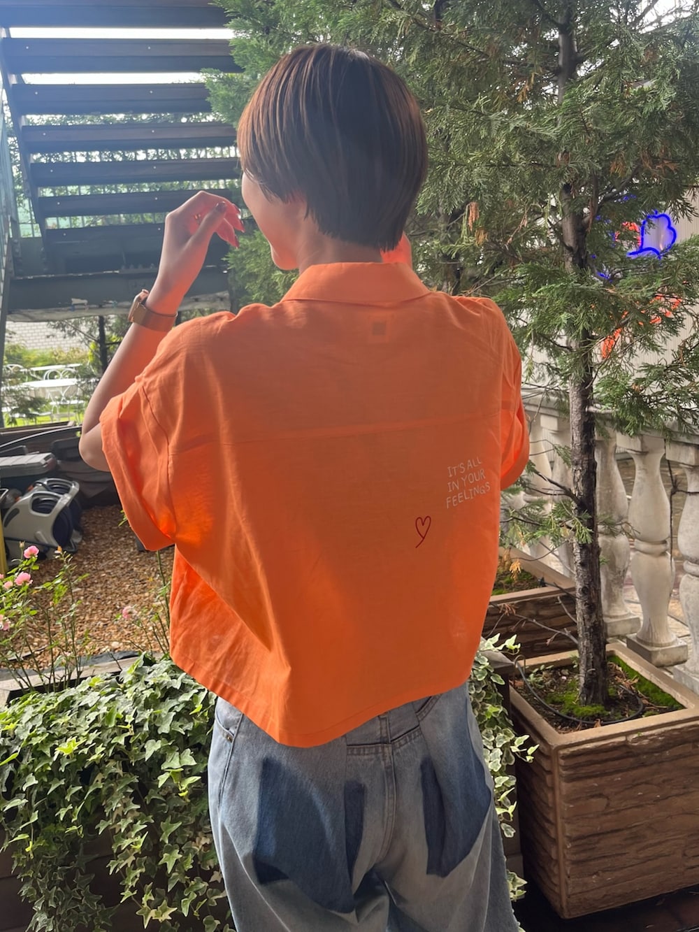 オレンジ系のシャツ/ブラウス、ブルー系のデニムパンツを着用したレディースの夏コーディネートの5枚目の写真