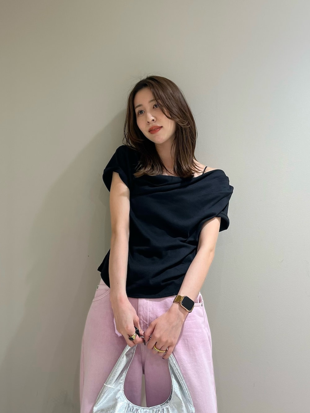 ブラック系のTシャツ/カットソー、ピンク系のデニムパンツ、シルバー系のハンドバッグを着用したレディースの春コーディネートの4枚目の写真