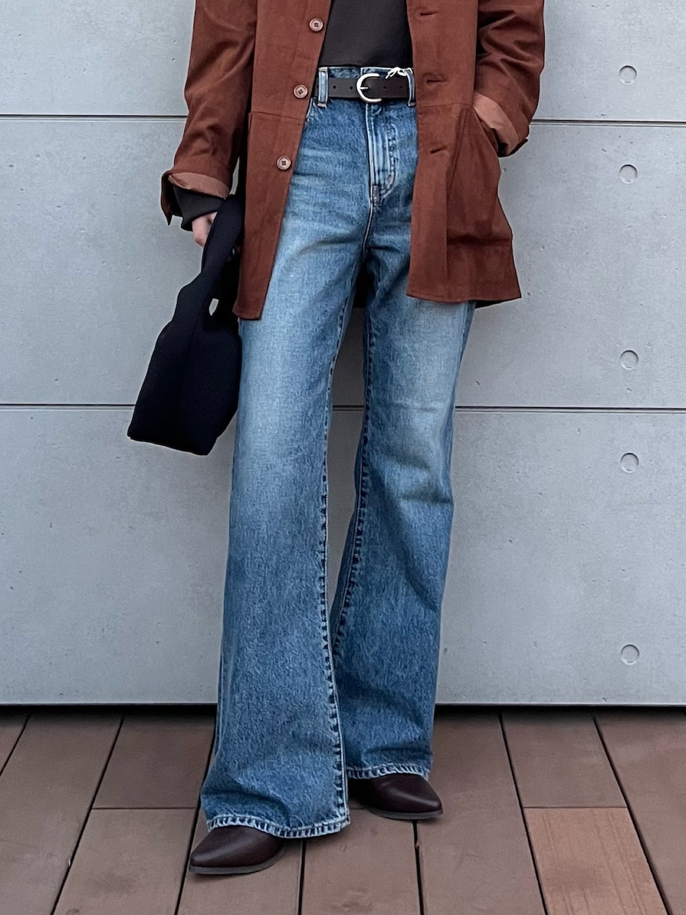 グレー系のTシャツ/カットソー、ブルー系のデニムパンツ、ブラック系のハンドバッグを着用したレディースの冬コーディネートの6枚目の写真