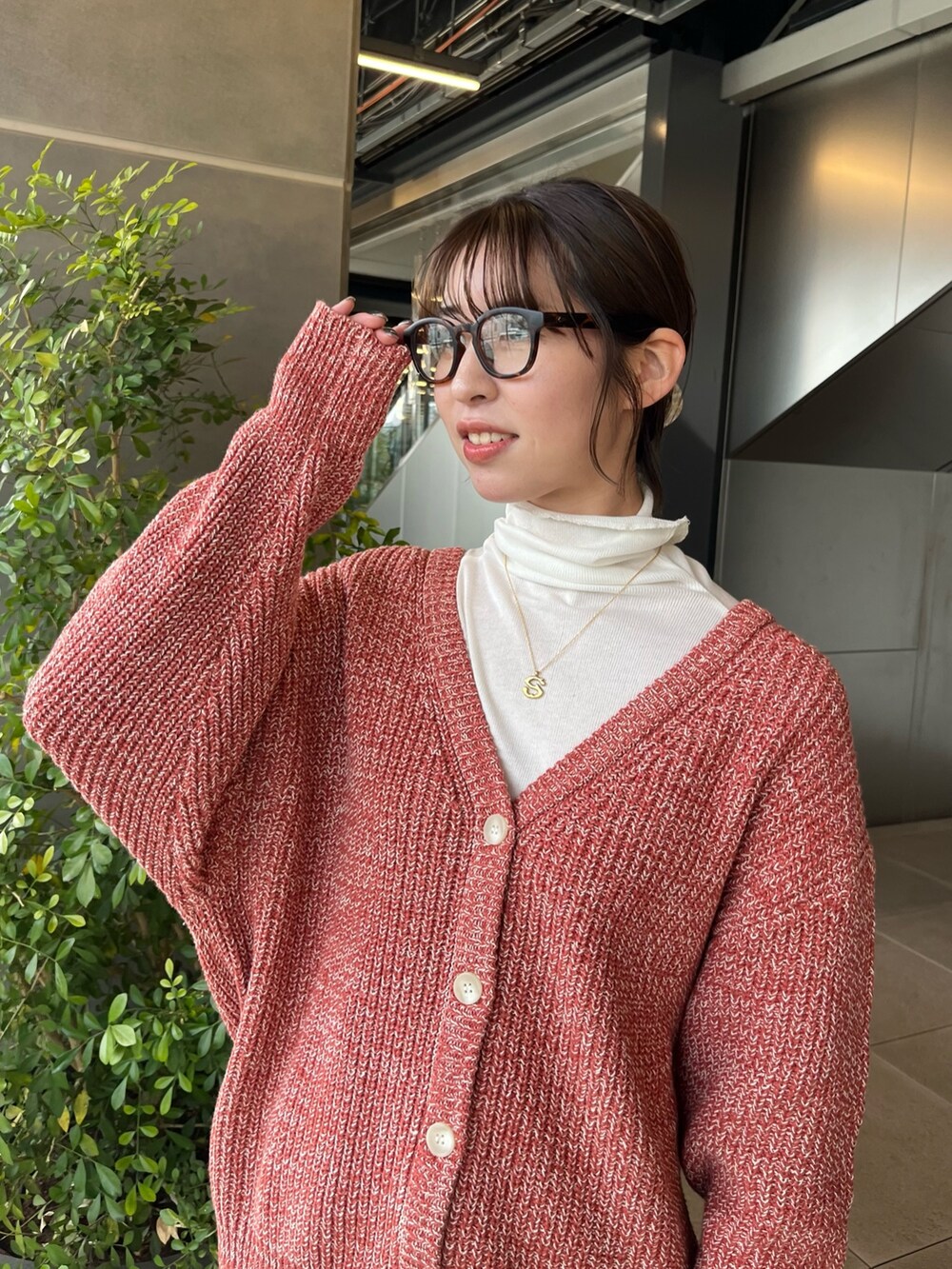 ホワイト系のTシャツ/カットソー、オレンジ系のカーディガン/ボレロ、ブルー系のデニムパンツを着用したレディースの冬コーディネートの4枚目の写真