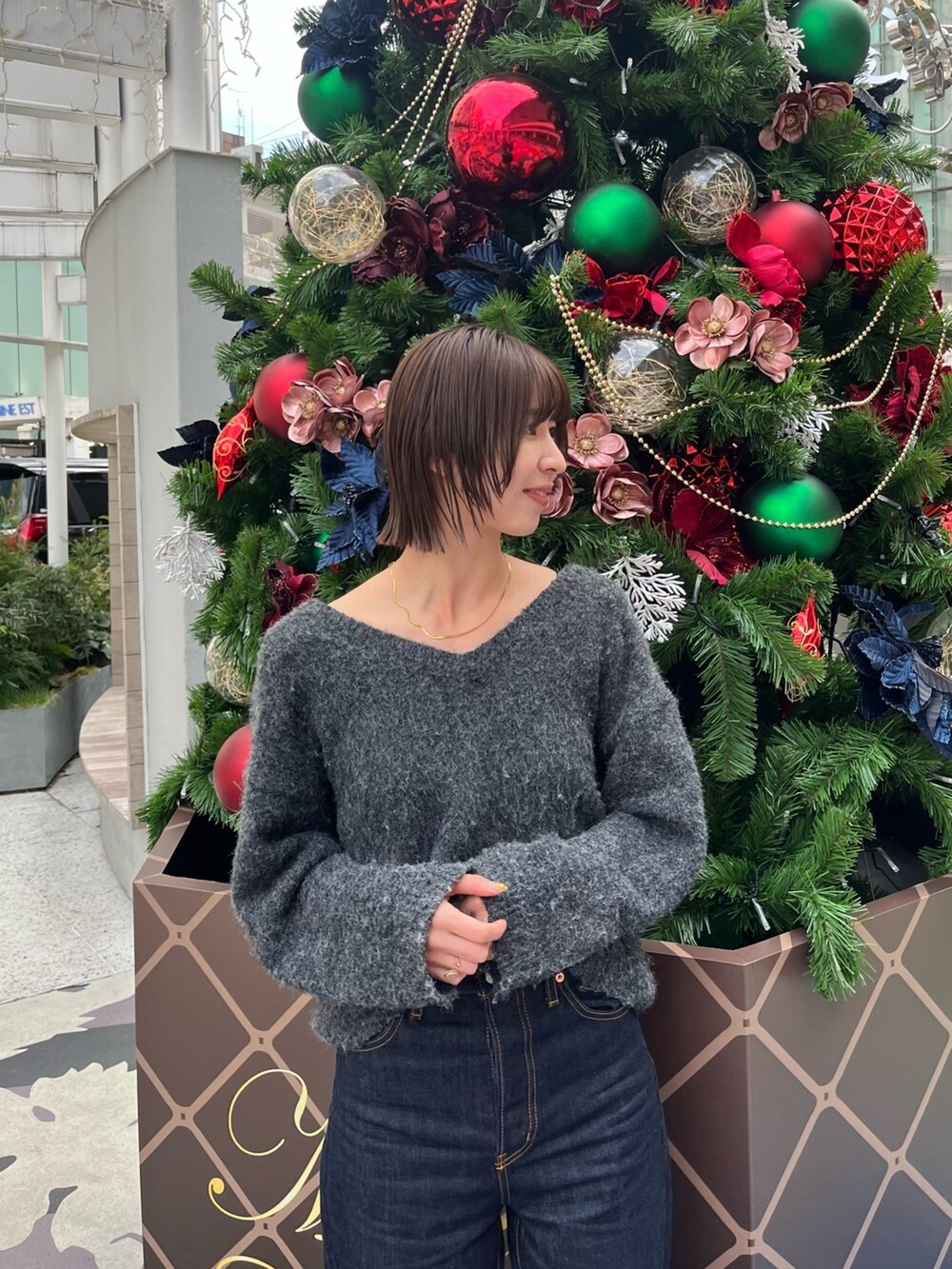 グレー系のニット/セーター、ブルー系のデニムパンツを着用したレディースの冬コーディネートの2枚目の写真