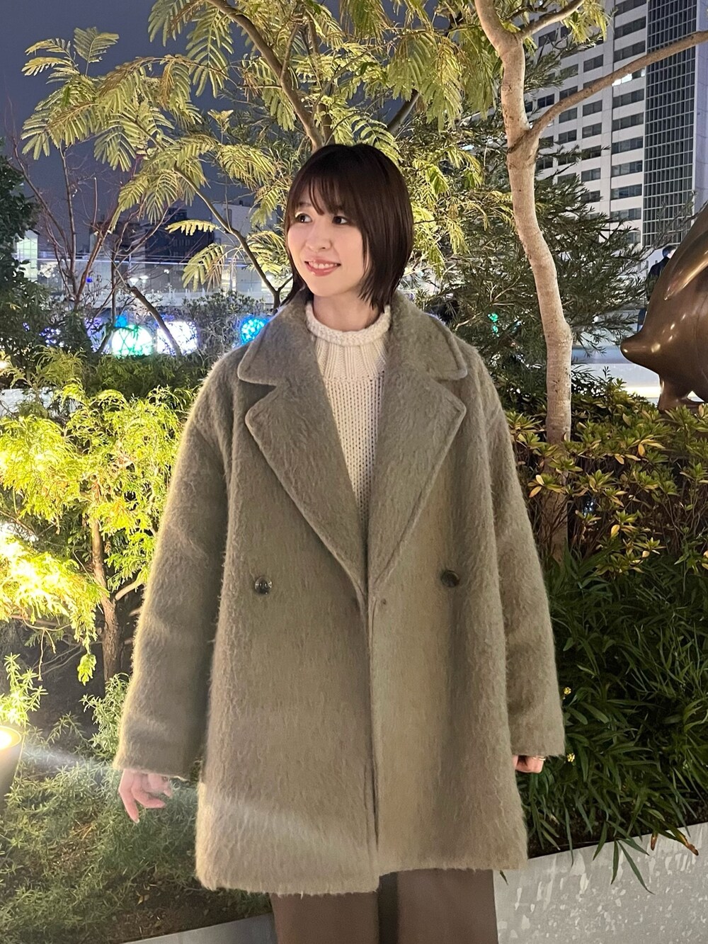 ホワイト系のニット/セーター、グリーン系のピーコート、ブラウン系のその他パンツを着用したレディースの冬コーディネートの2枚目の写真