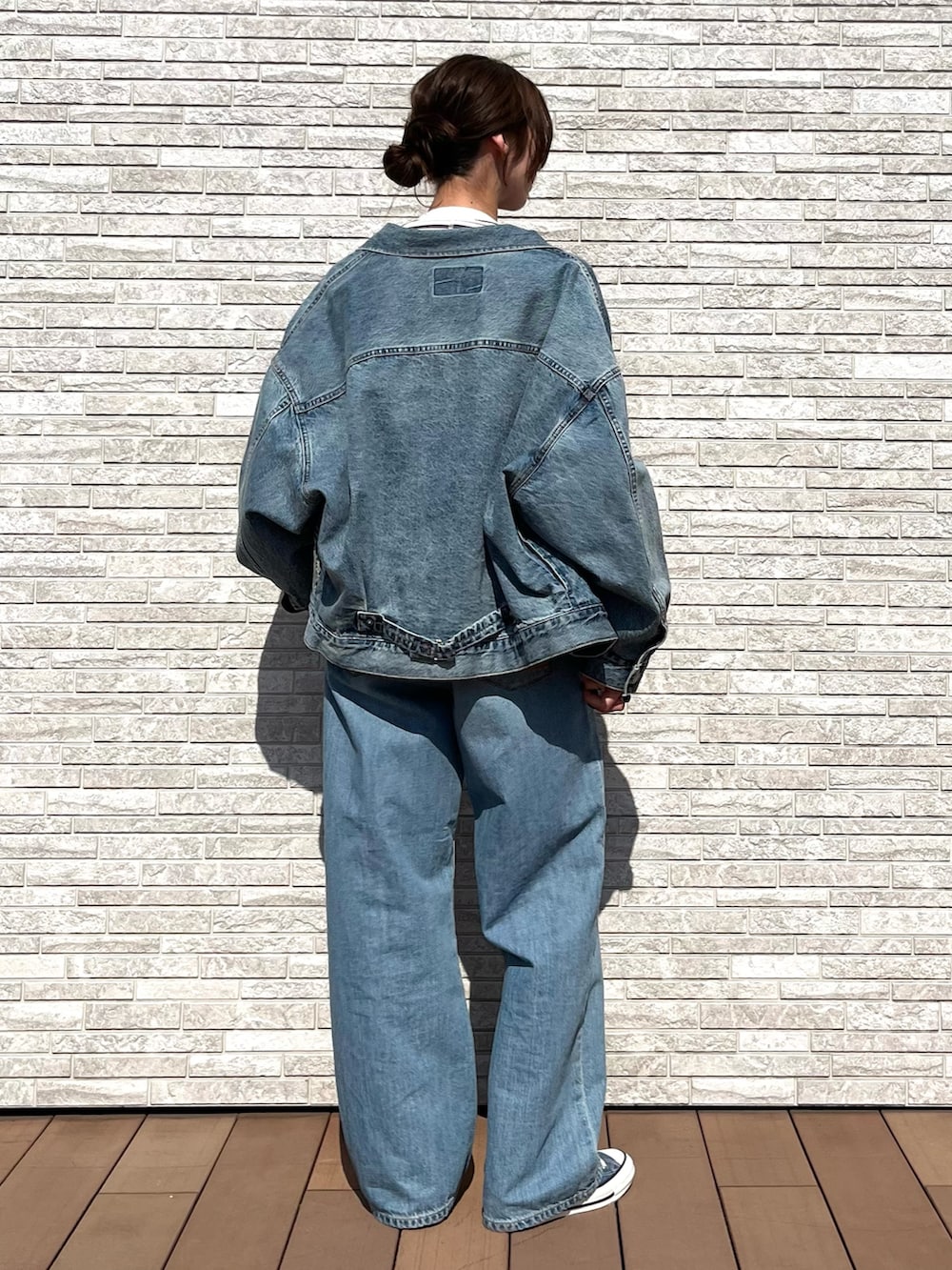 ホワイト系のTシャツ/カットソー、ブルー系のデニムジャケット、ブルー系のデニムパンツを着用したレディースの冬コーディネートの4枚目の写真