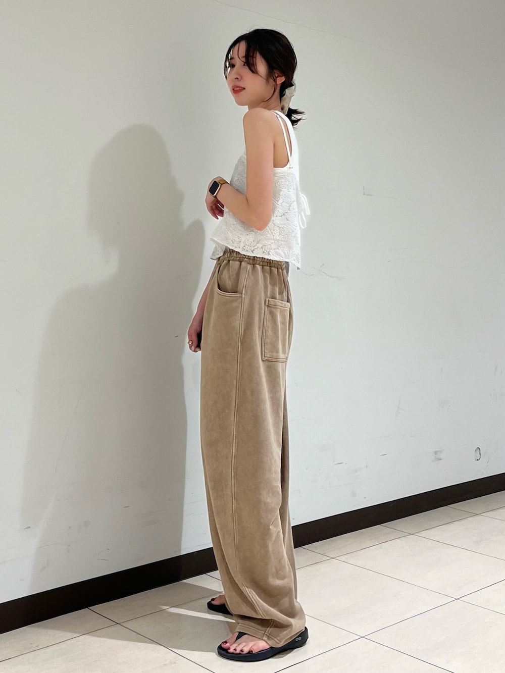 ホワイト系のキャミソール、ベージュ系のスウェットパンツを着用したレディースの夏コーディネートの2枚目の写真