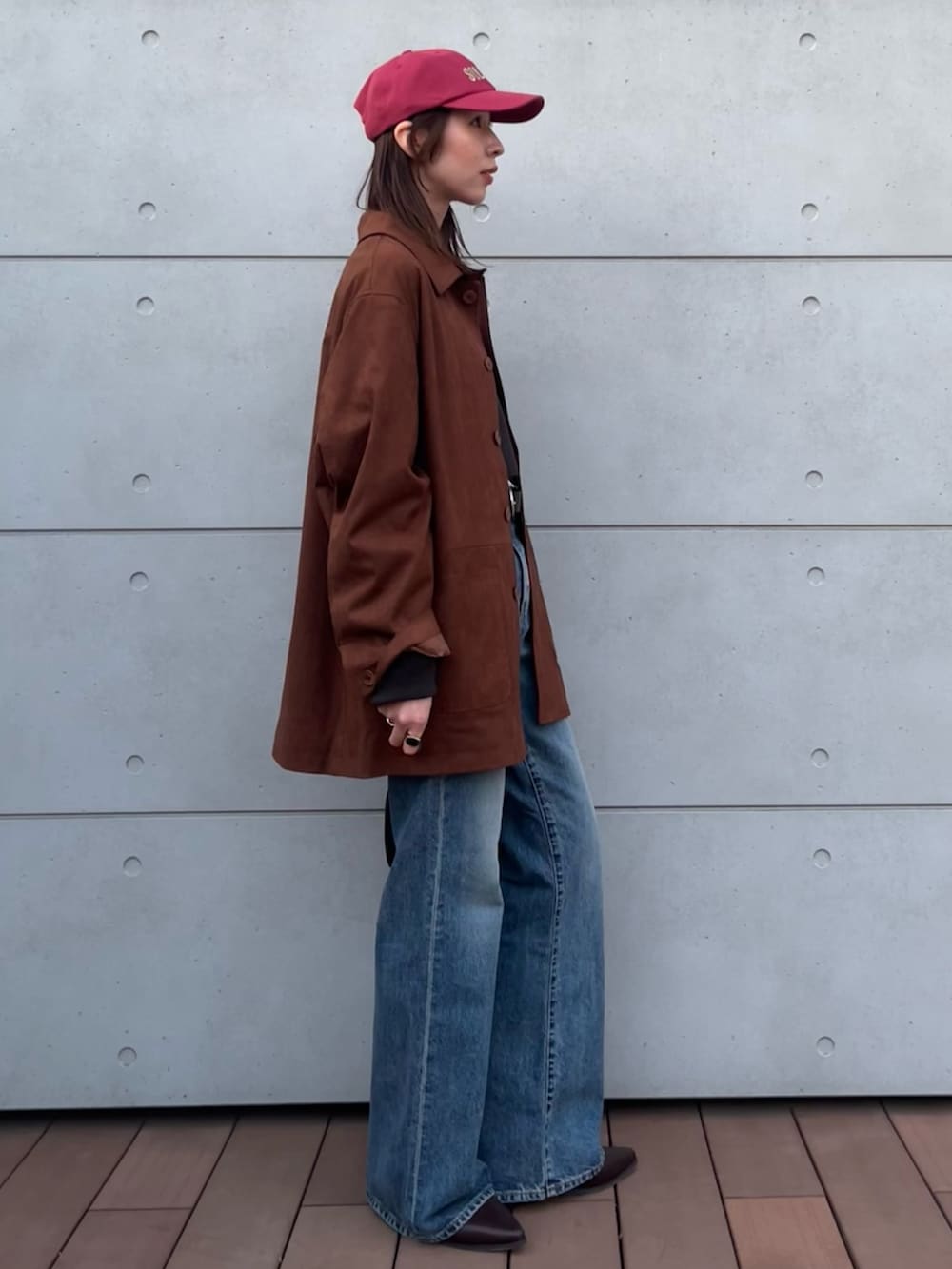 グレー系のTシャツ/カットソー、ブルー系のデニムパンツ、ブラック系のハンドバッグを着用したレディースの冬コーディネートの3枚目の写真