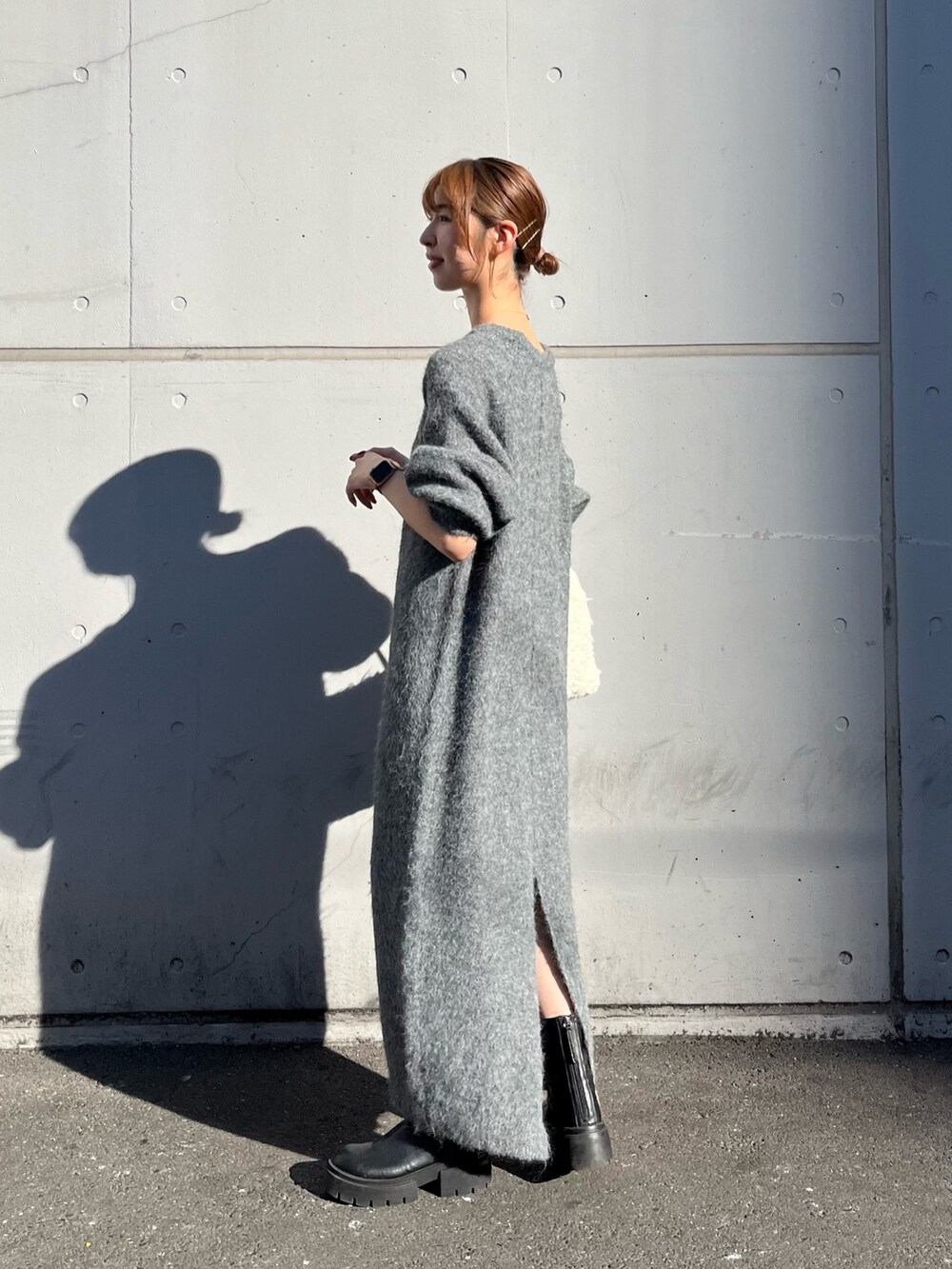 ホワイト系のハンドバッグ、グレー系のワンピースを着用したレディースの秋コーディネートの3枚目の写真