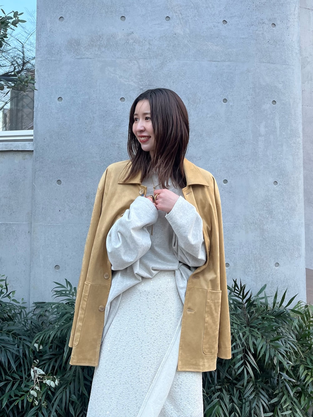 イエロー系のテーラードジャケット、グレー系のTシャツ/カットソー、ホワイト系のスカートを着用したレディースの冬コーディネートの4枚目の写真