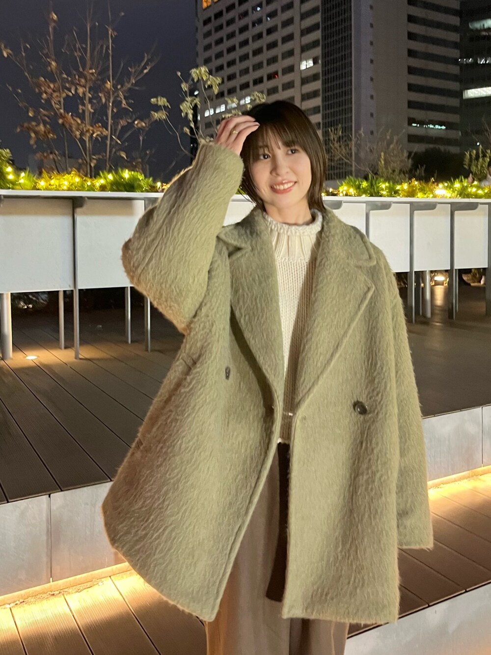 ホワイト系のニット/セーター、グリーン系のピーコート、ブラウン系のその他パンツを着用したレディースの冬コーディネートの3枚目の写真