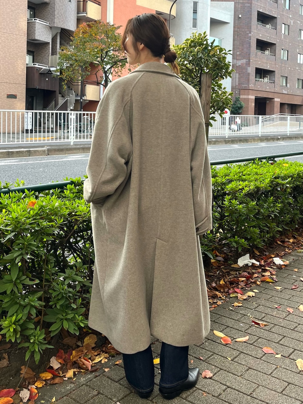 ブルー系のシャツ/ブラウス、グレー系のチェスターコート、ブルー系のデニムパンツを着用したレディースの秋コーディネートの3枚目の写真