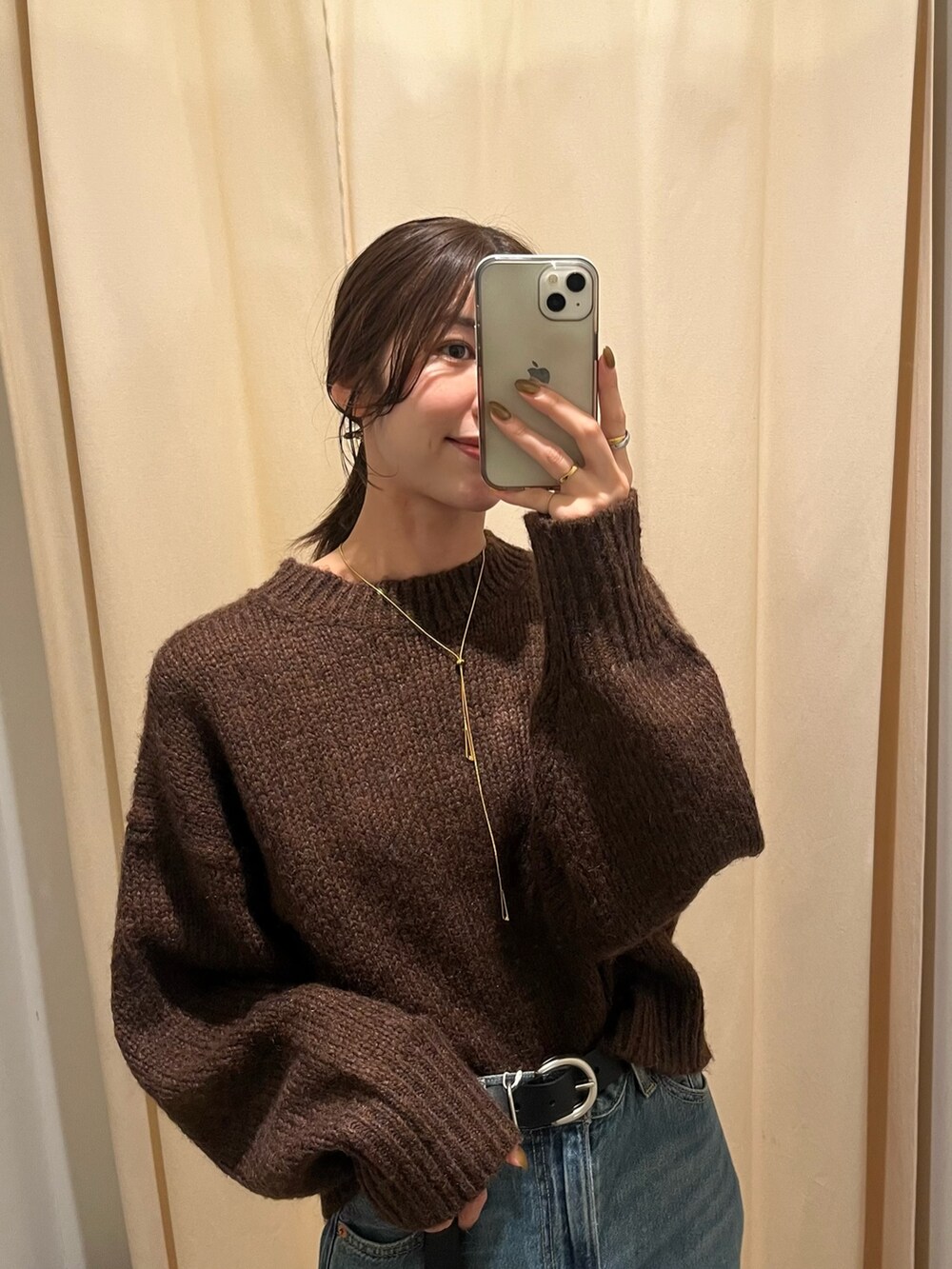 ブラウン系のニット/セーター、ブルー系のデニムパンツ、ピンク系のハンドバッグを着用したレディースの秋コーディネートの4枚目の写真