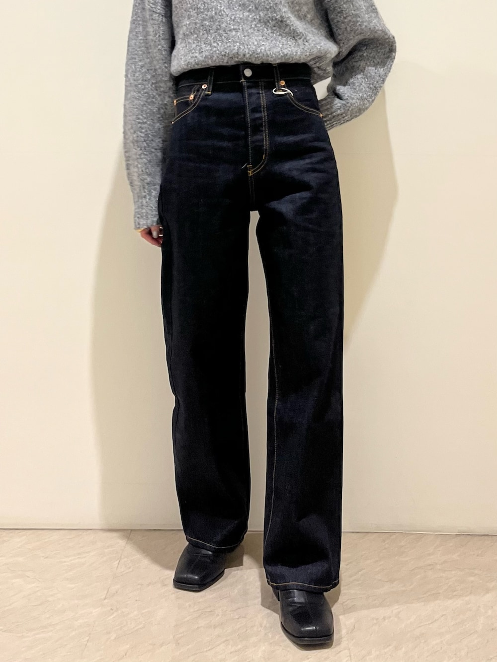 グレー系のニット/セーター、ブルー系のデニムパンツを着用したレディースの秋コーディネートの5枚目の写真