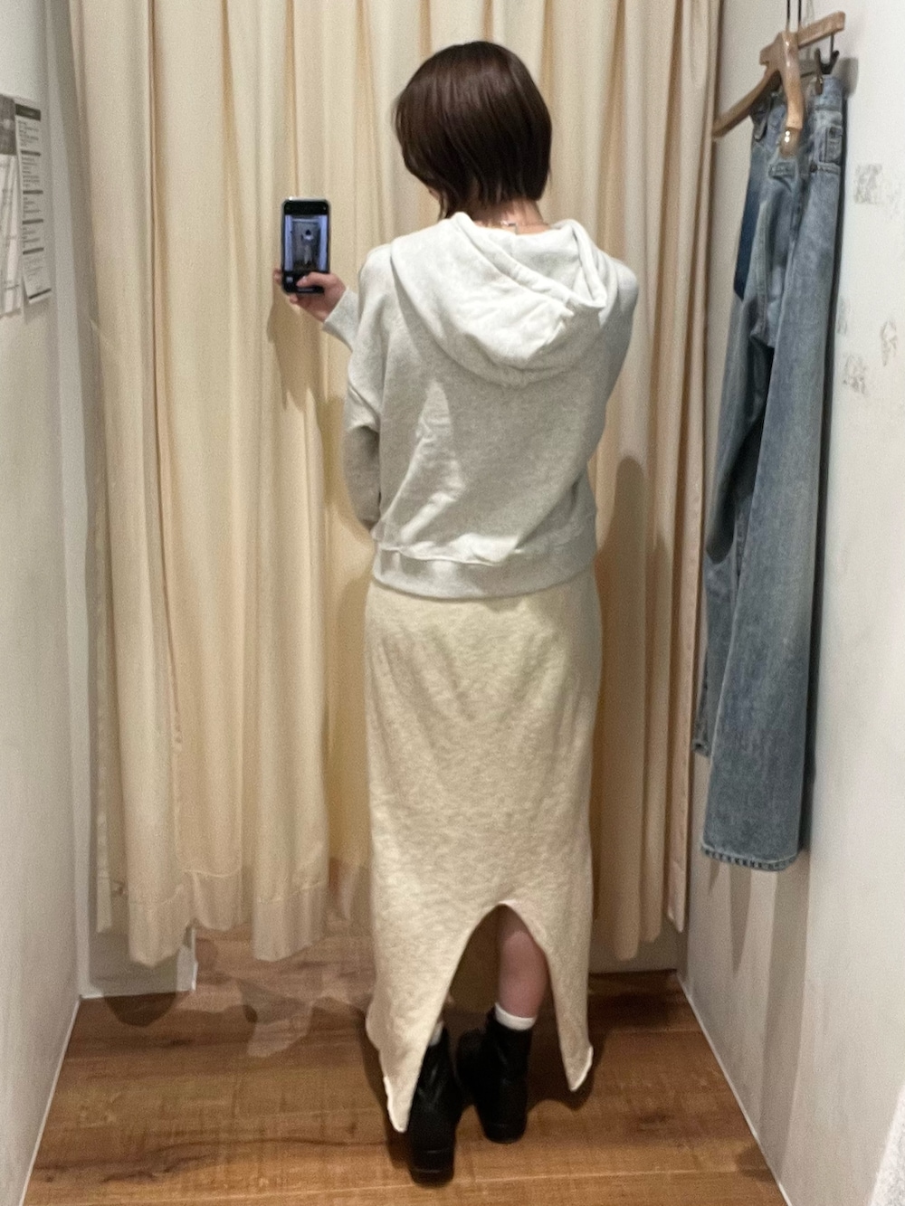 グレー系のパーカー、ホワイト系のスカートを着用したレディースの冬コーディネートの3枚目の写真