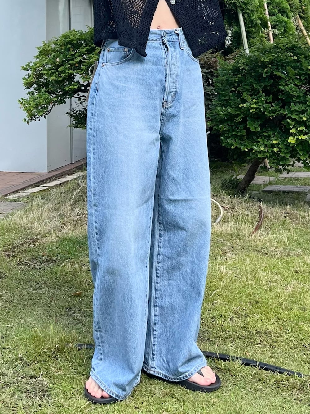 ブラック系のシャツ/ブラウス、ブルー系のデニムパンツを着用したレディースの夏コーディネートの6枚目の写真