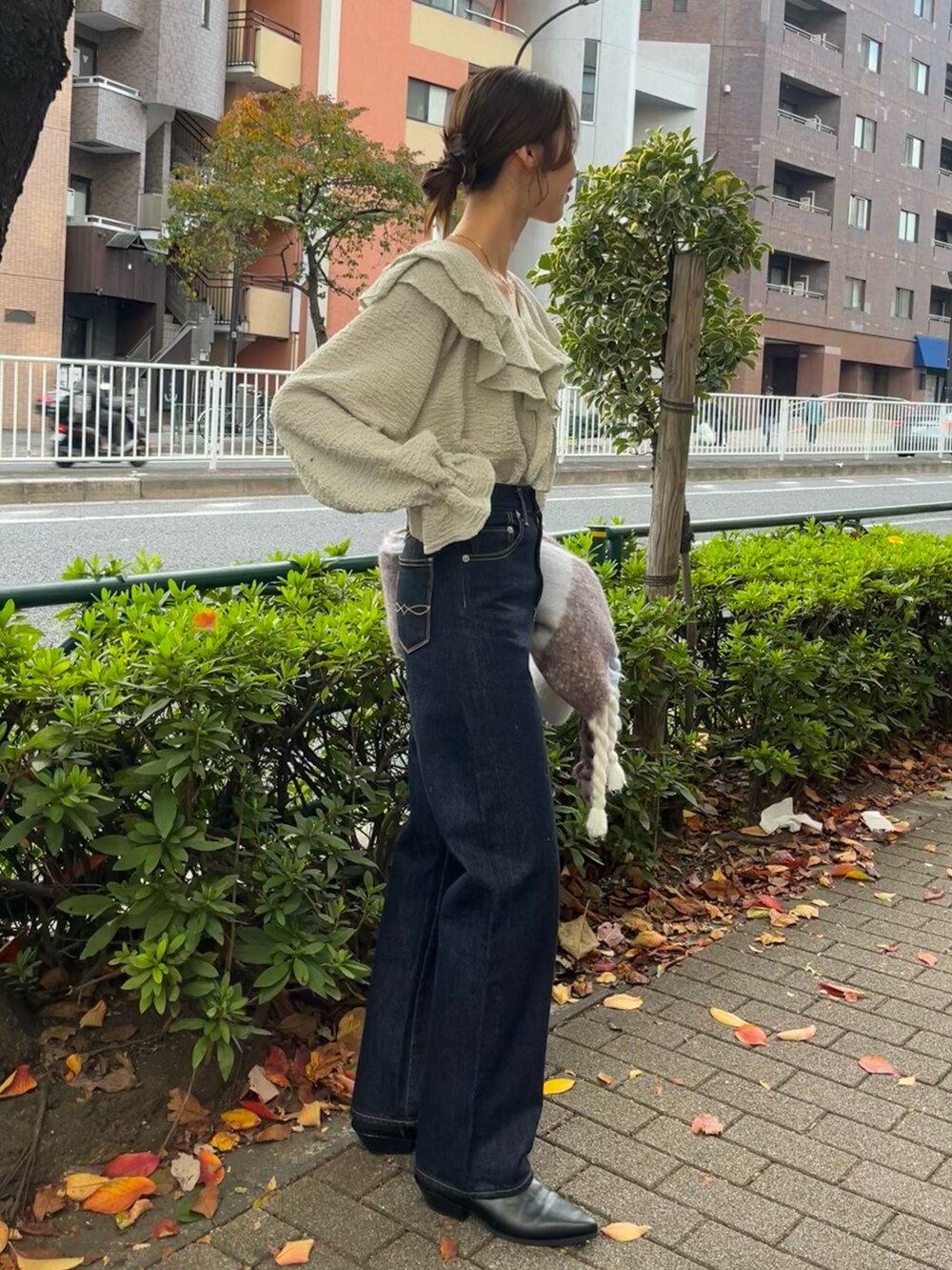 ブルー系のシャツ/ブラウス、グレー系のチェスターコート、ブルー系のデニムパンツを着用したレディースの秋コーディネートの5枚目の写真