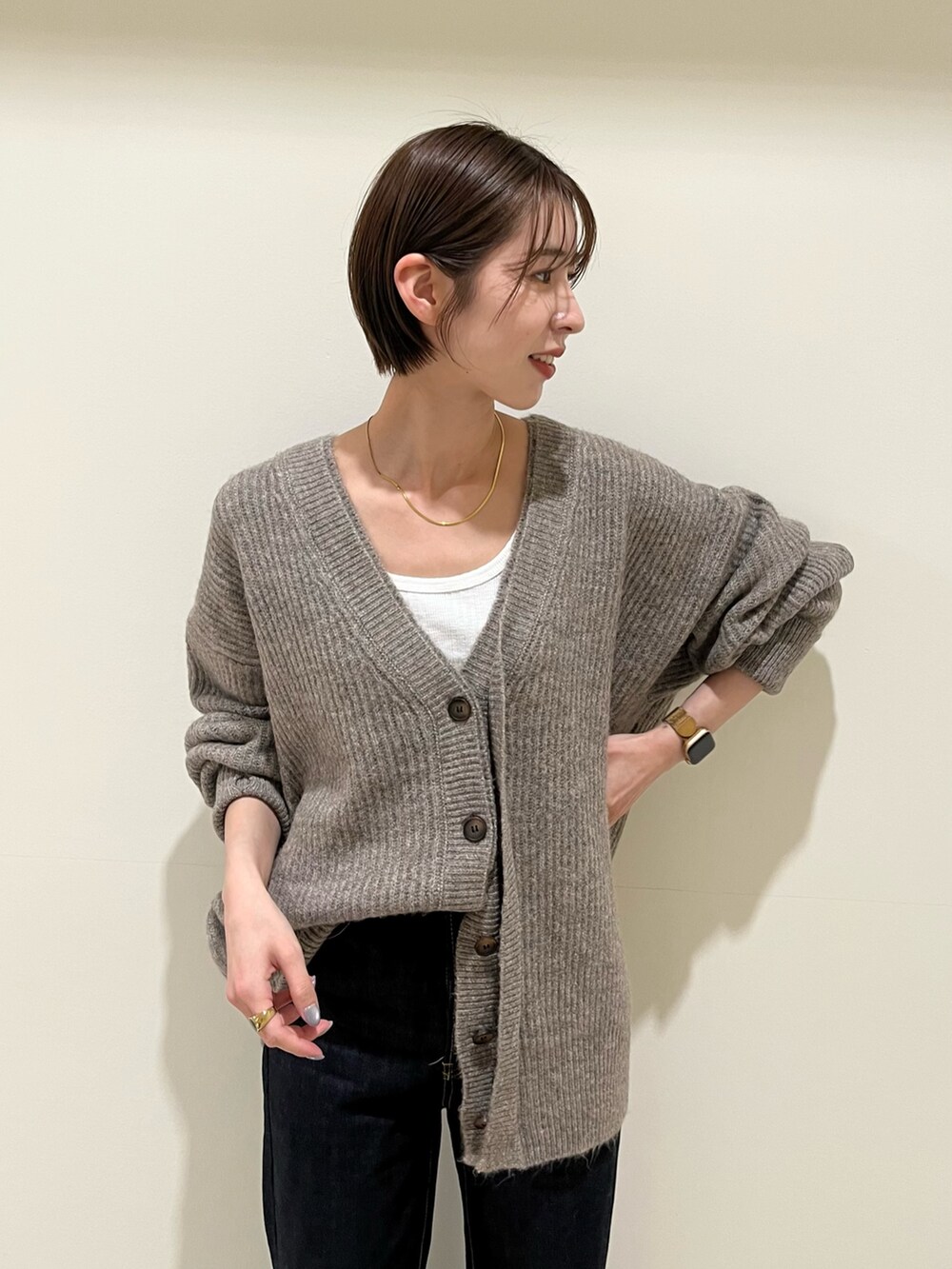 グレー系のカーディガン/ボレロ、ブルー系のデニムパンツを着用したレディースの秋コーディネートの4枚目の写真