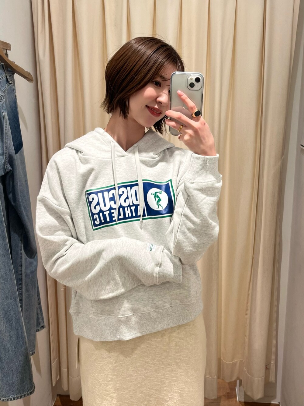 グレー系のパーカー、ホワイト系のスカートを着用したレディースの冬コーディネートの4枚目の写真