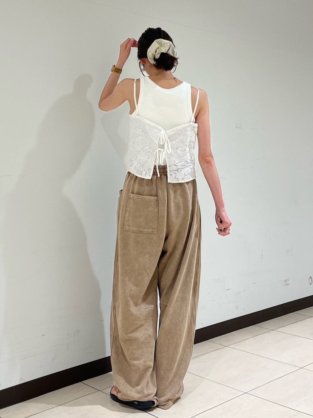 ホワイト系のキャミソール、ベージュ系のスウェットパンツを着用したレディースの夏コーディネートの3枚目の写真