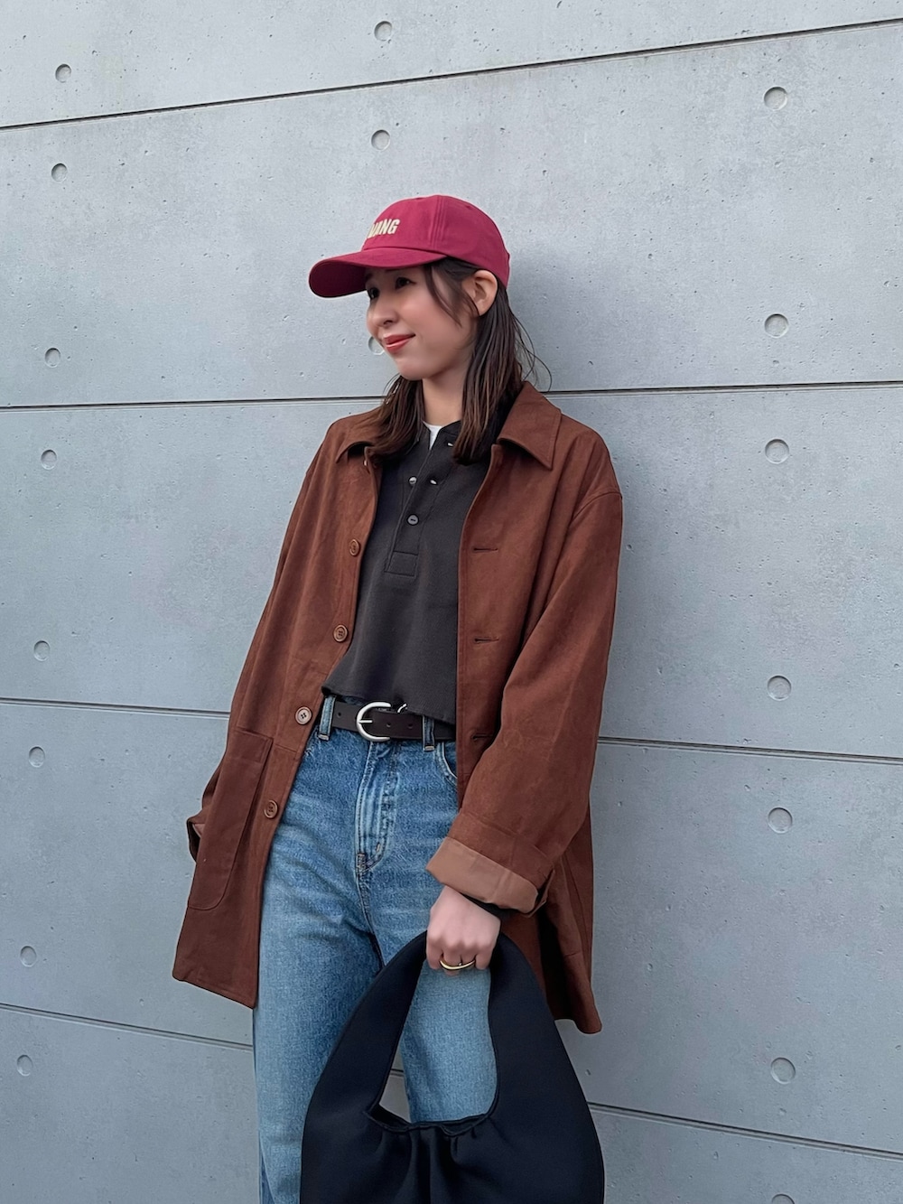 グレー系のTシャツ/カットソー、ブルー系のデニムパンツ、ブラック系のハンドバッグを着用したレディースの冬コーディネートの5枚目の写真