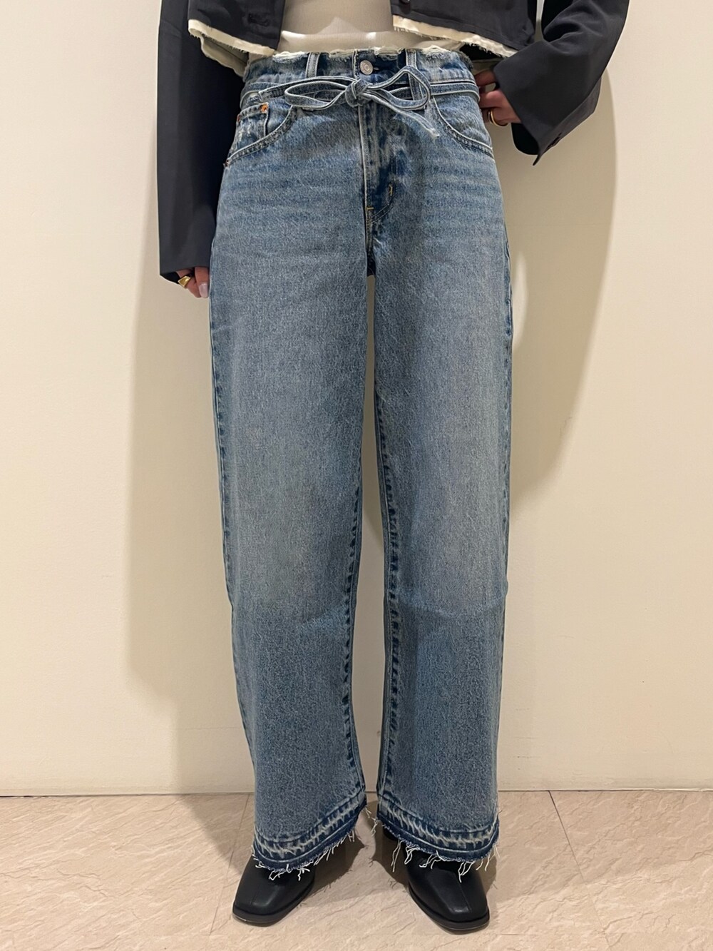 グレー系のテーラードジャケット、グレー系のキャミソール、ブルー系のデニムパンツを着用したレディースの夏コーディネートの5枚目の写真