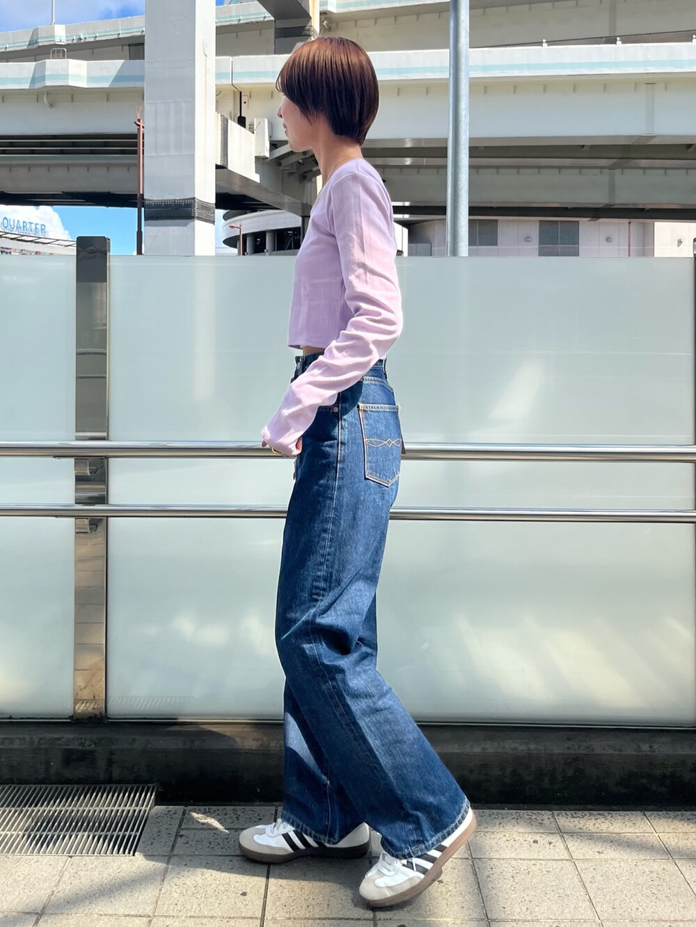 パープル系のTシャツ/カットソー、ブルー系のデニムパンツを着用したレディースの夏コーディネートの2枚目の写真