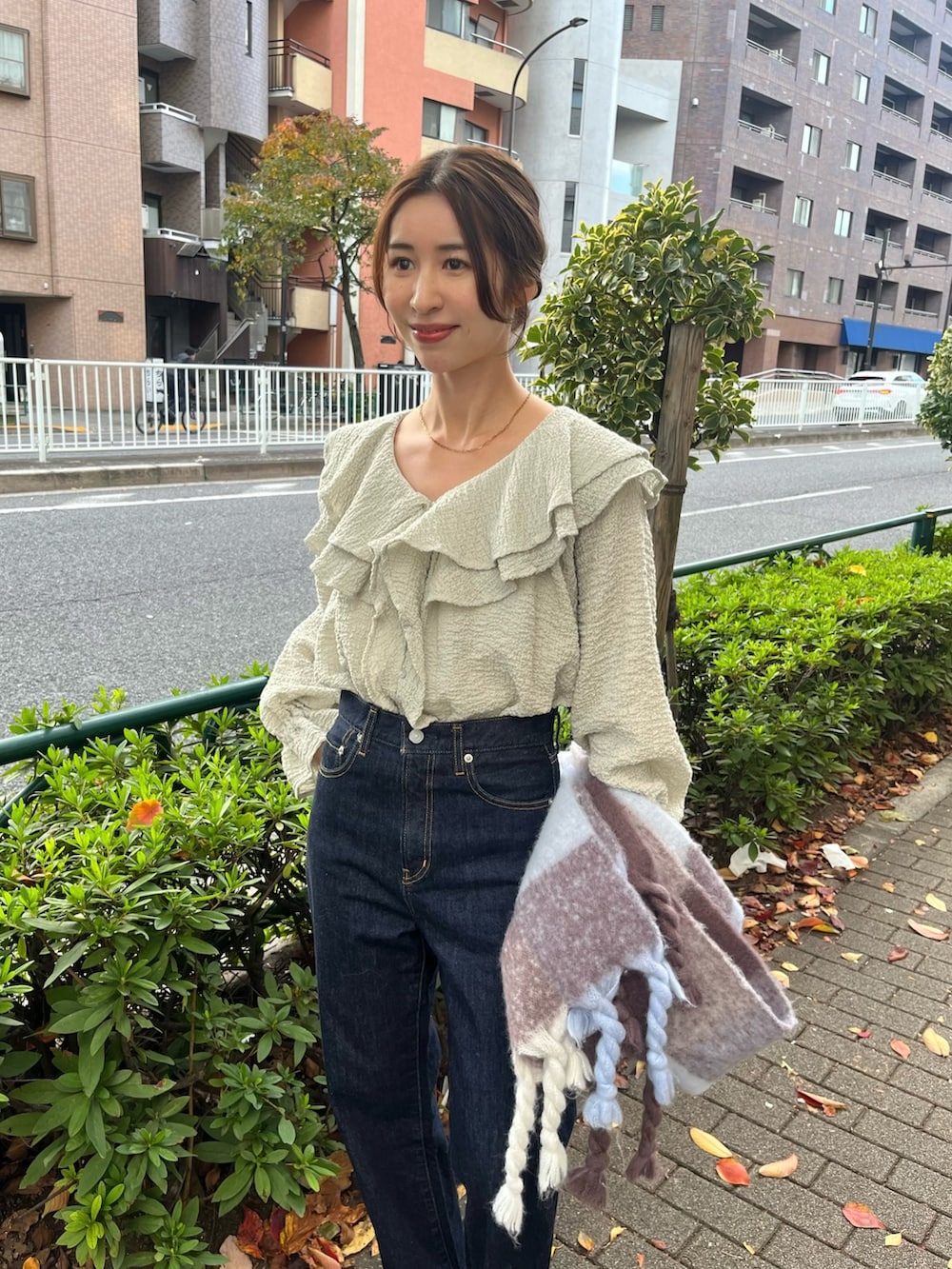 ブルー系のシャツ/ブラウス、グレー系のチェスターコート、ブルー系のデニムパンツを着用したレディースの秋コーディネートの7枚目の写真