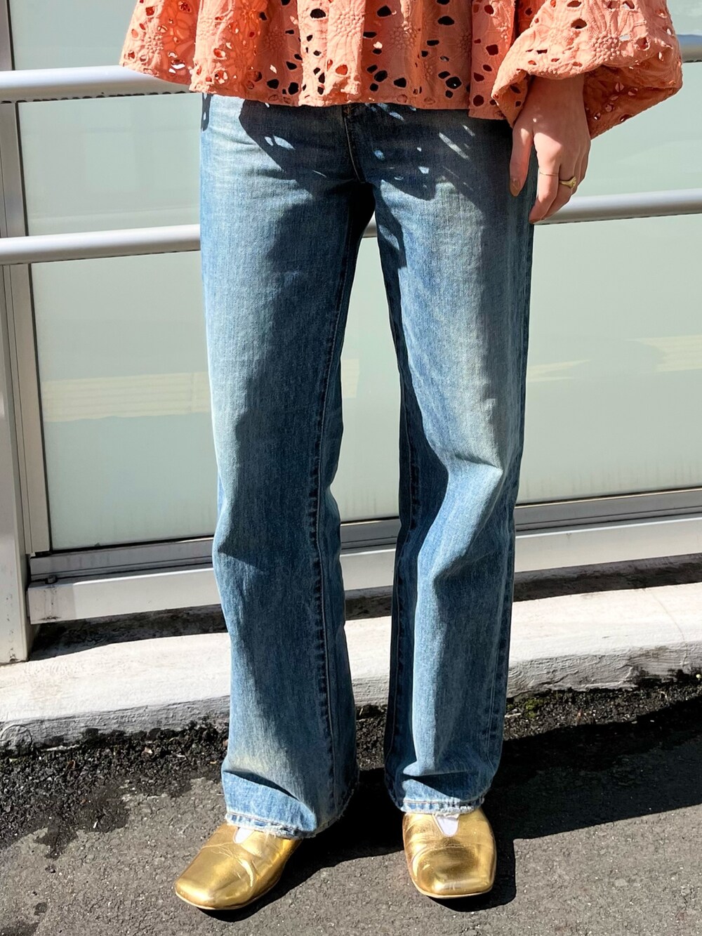 オレンジ系のシャツ/ブラウス、ブルー系のデニムパンツ、ゴールド系のパンプスを着用したレディースの冬コーディネートの4枚目の写真