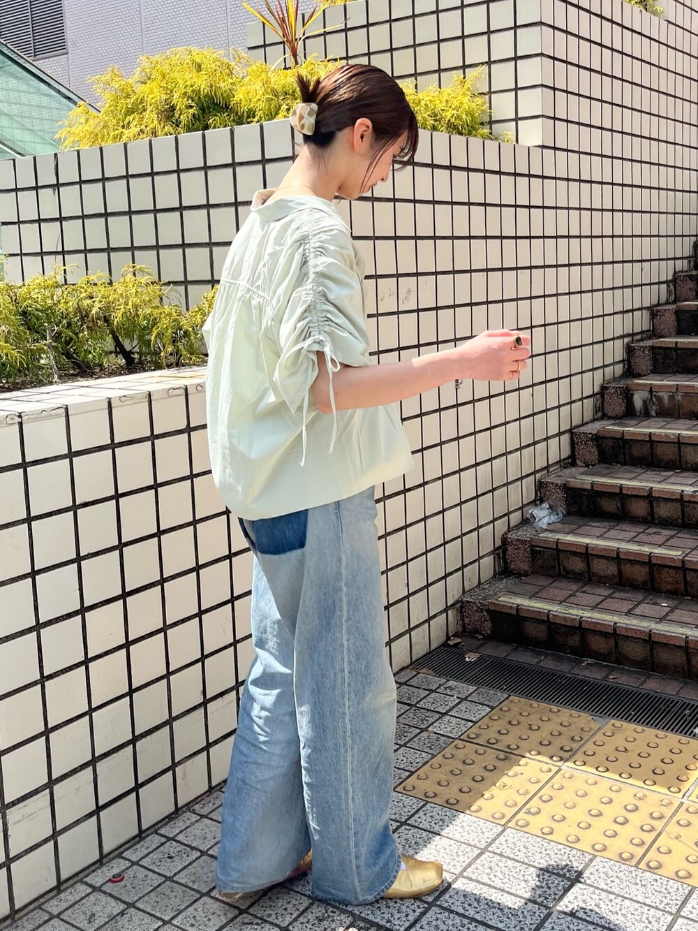 グリーン系のシャツ/ブラウス、ブルー系のデニムパンツを着用したレディースの春コーディネートの3枚目の写真