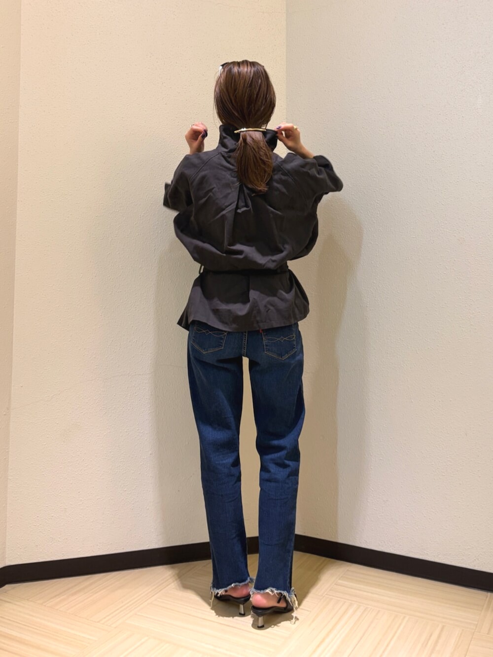 グレー系のトレンチコート、ブルー系のデニムパンツ、ブラック系のサングラスを着用したレディースの夏コーディネートの3枚目の写真