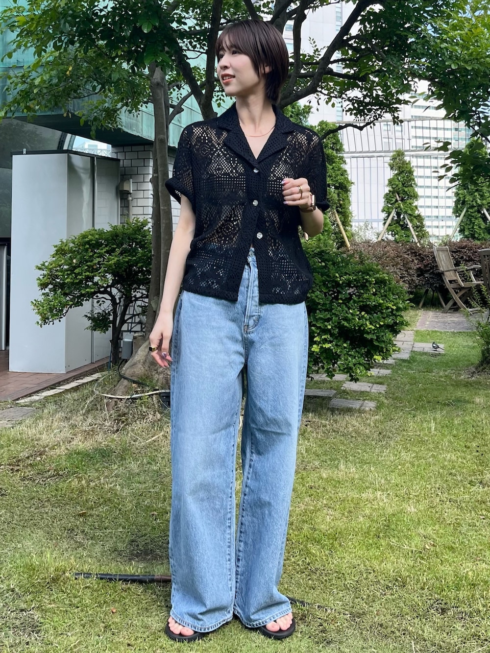 ブラック系のシャツ/ブラウス、ブルー系のデニムパンツを着用したレディースの夏コーディネートの2枚目の写真