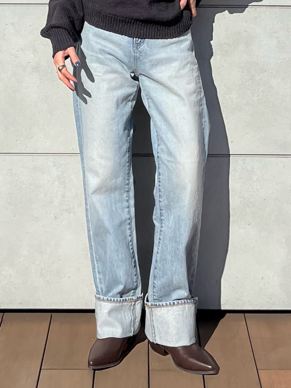 グレー系のニット/セーター、ブルー系のデニムパンツ、ブラウン系のハンドバッグを着用したレディースの冬コーディネートの5枚目の写真