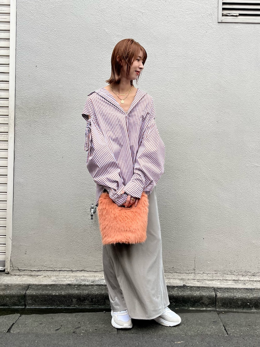 オレンジ系のハンドバッグ、ブラウン系のシャツ/ブラウス、グレー系のスカートを着用したレディースの秋コーディネートの2枚目の写真