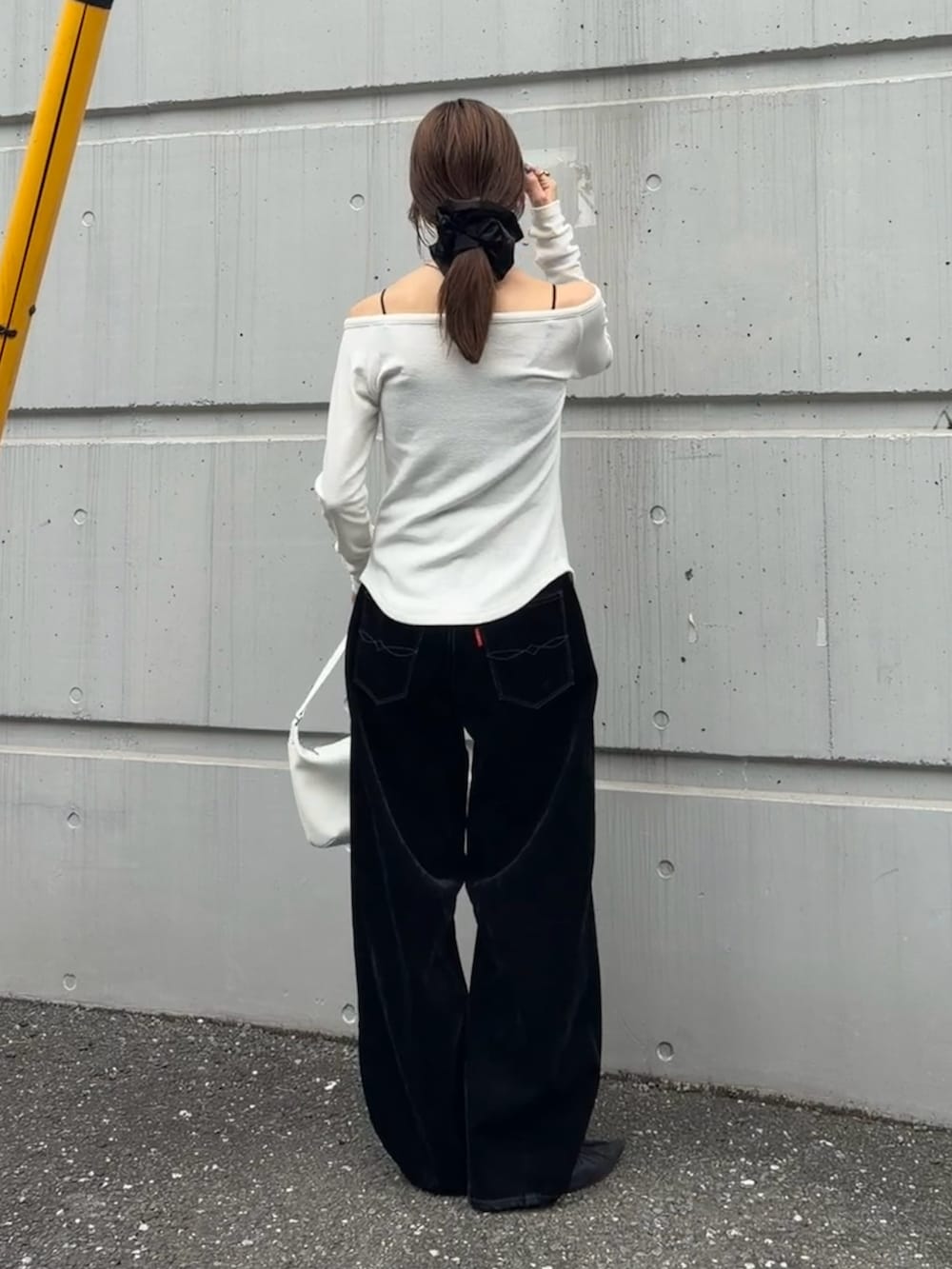 ホワイト系のTシャツ/カットソー、ブラック系のデニムパンツ、ホワイト系のハンドバッグを着用したレディースの秋コーディネートの3枚目の写真