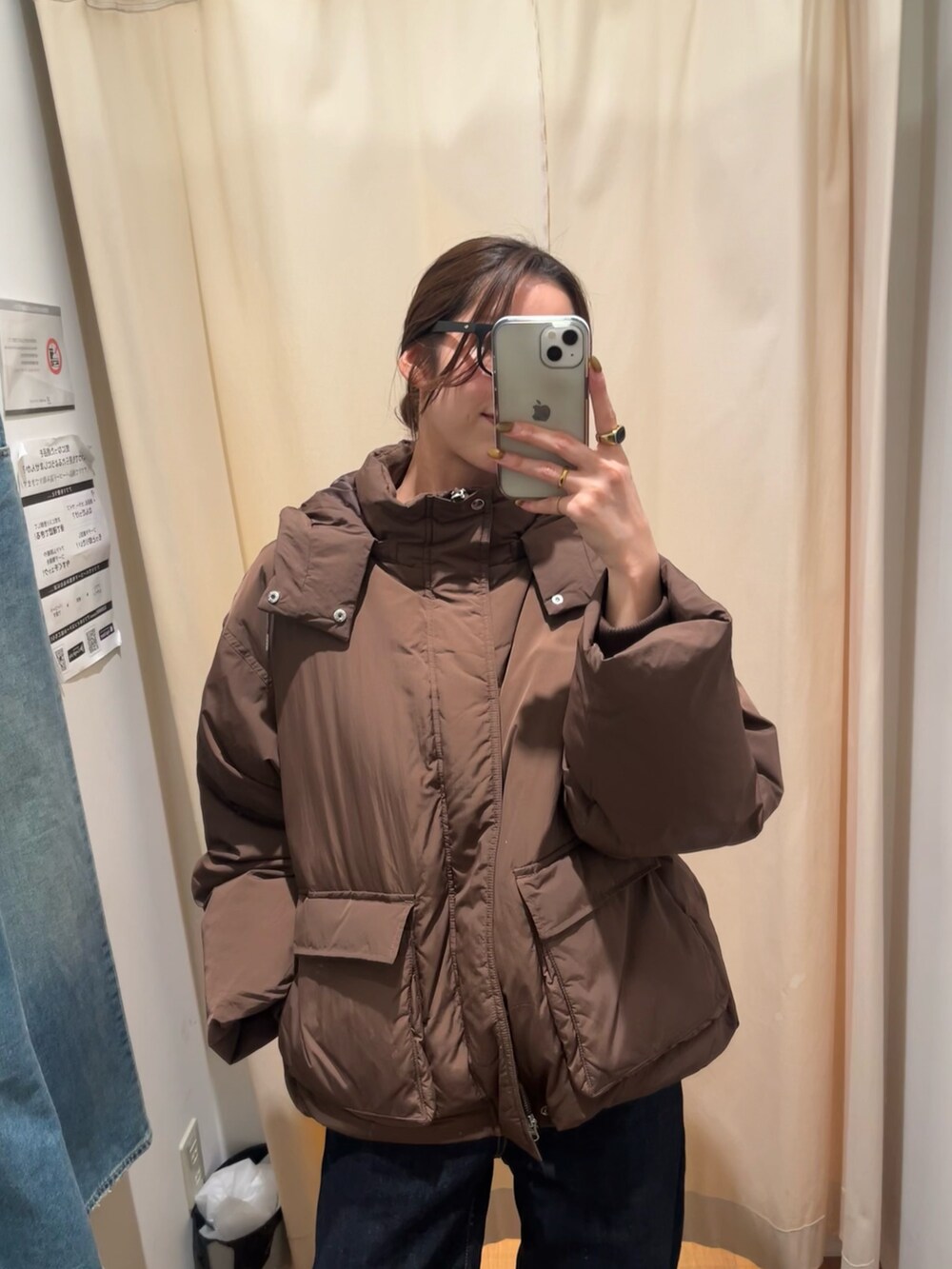 ブラウン系のダウンジャケット/コート、ブルー系のデニムパンツ、ブラック系のサングラスを着用したレディースの冬コーディネートの6枚目の写真