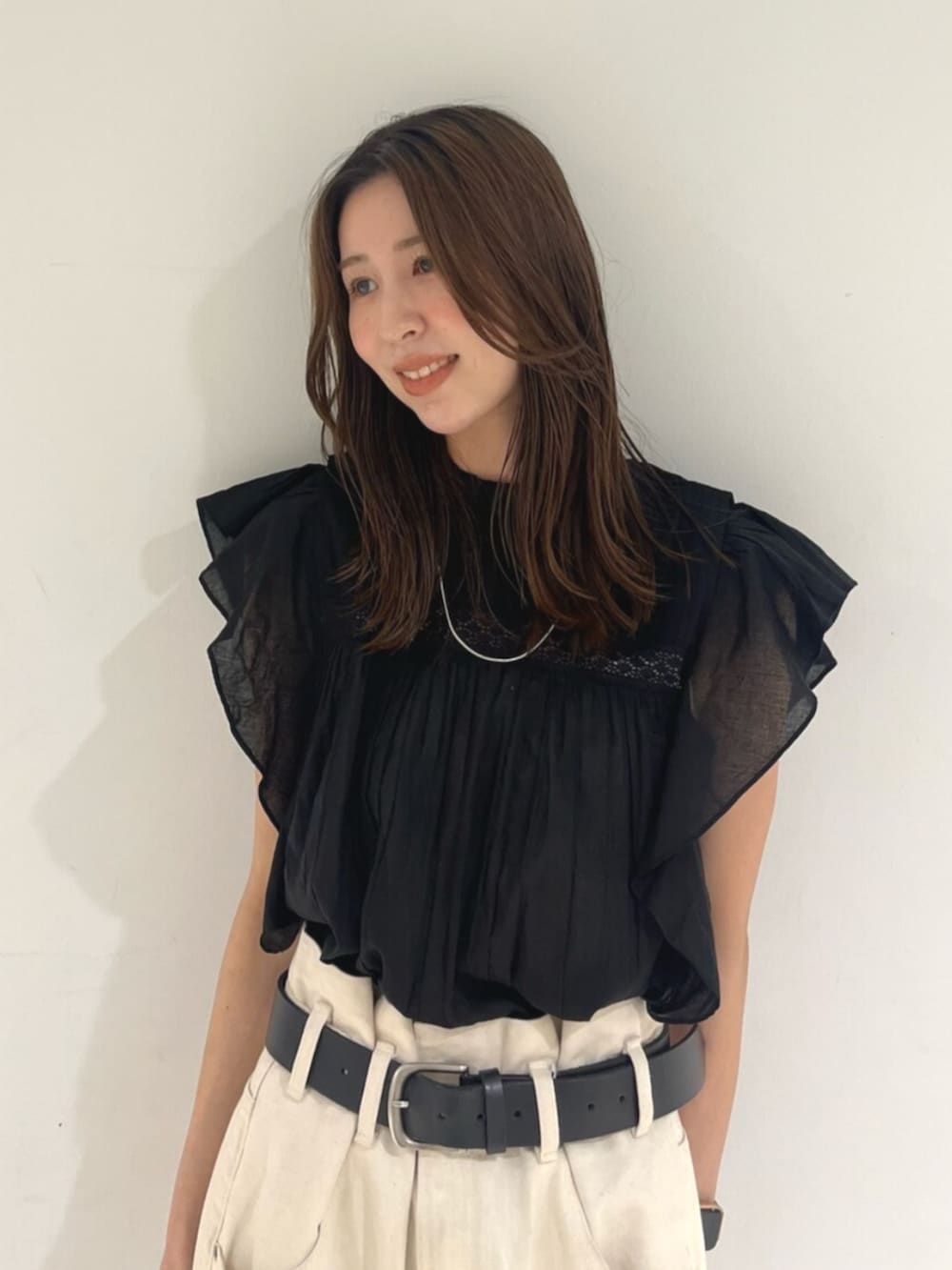 ブラック系のシャツ/ブラウス、ホワイト系のデニムパンツを着用したレディースの春コーディネートの4枚目の写真