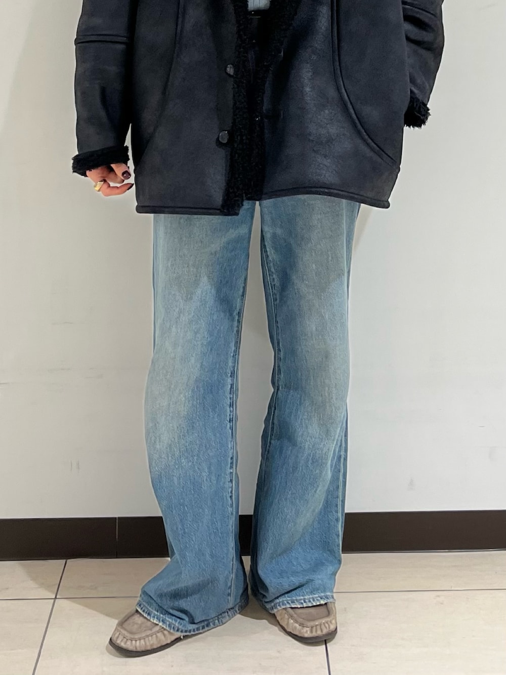ブラック系のブルゾン、ブルー系のデニムパンツ、ベージュ系のローファーを着用したレディースの冬コーディネートの5枚目の写真