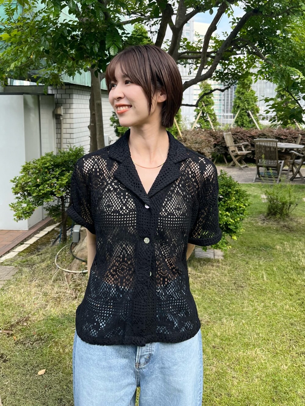 ブラック系のシャツ/ブラウス、ブルー系のデニムパンツを着用したレディースの夏コーディネートの5枚目の写真