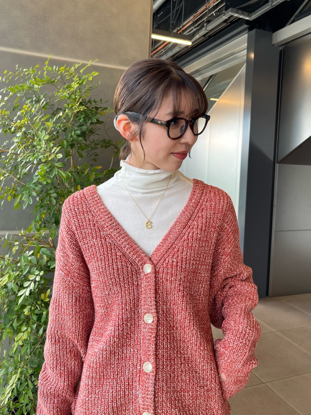 ホワイト系のTシャツ/カットソー、オレンジ系のカーディガン/ボレロ、ブルー系のデニムパンツを着用したレディースの冬コーディネートの3枚目の写真